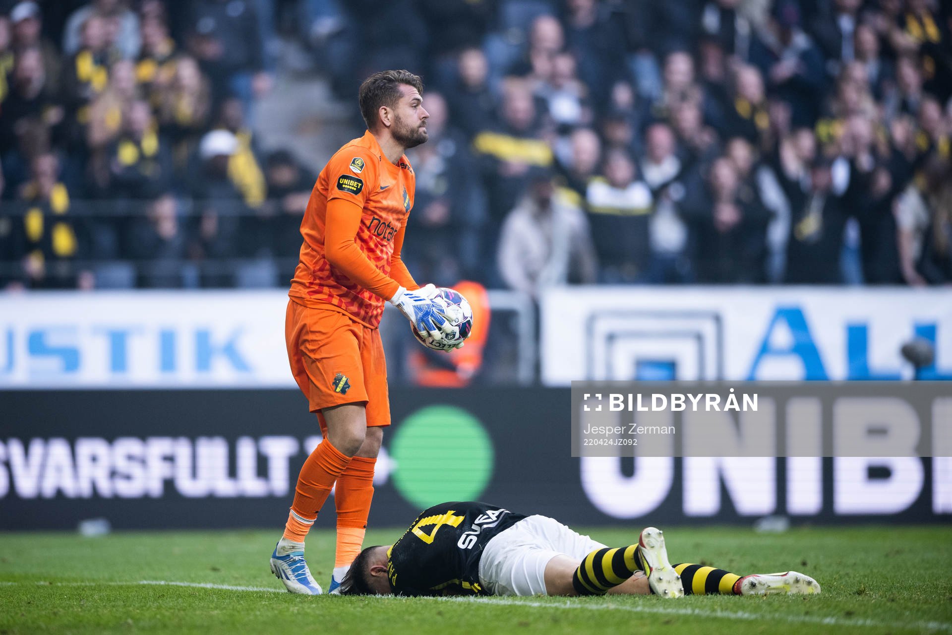 AIK:s Sotirios Papagiannopoulos har ont och målvakt Kristoffer Nordfeldt under fotbollsmatchen i Allsvenskan mellan AIK och Djurgården den 24 april 2022 i Stockholm.