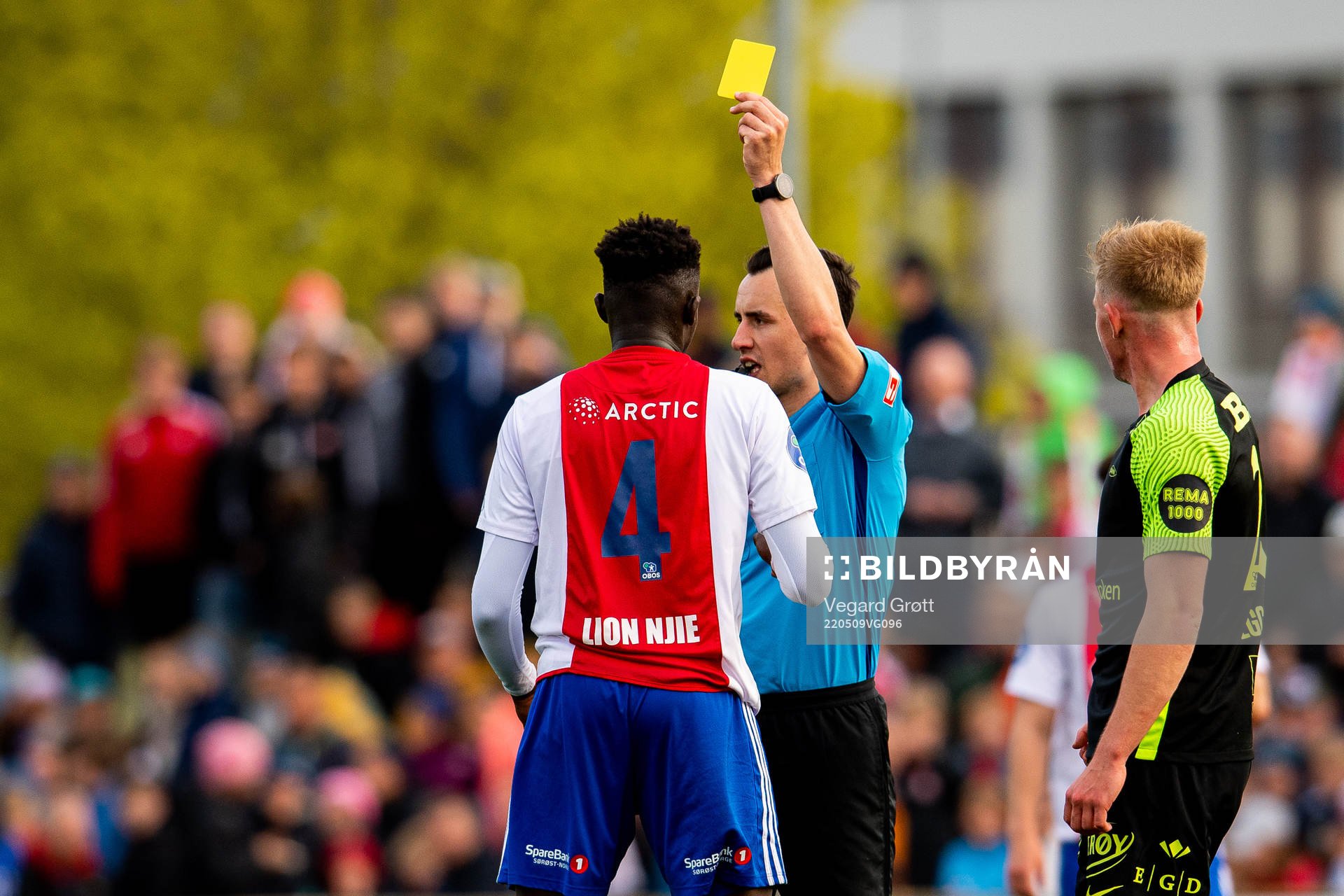 Momodou Lion Njie of KFUM is shown a yellow card by Mischa
