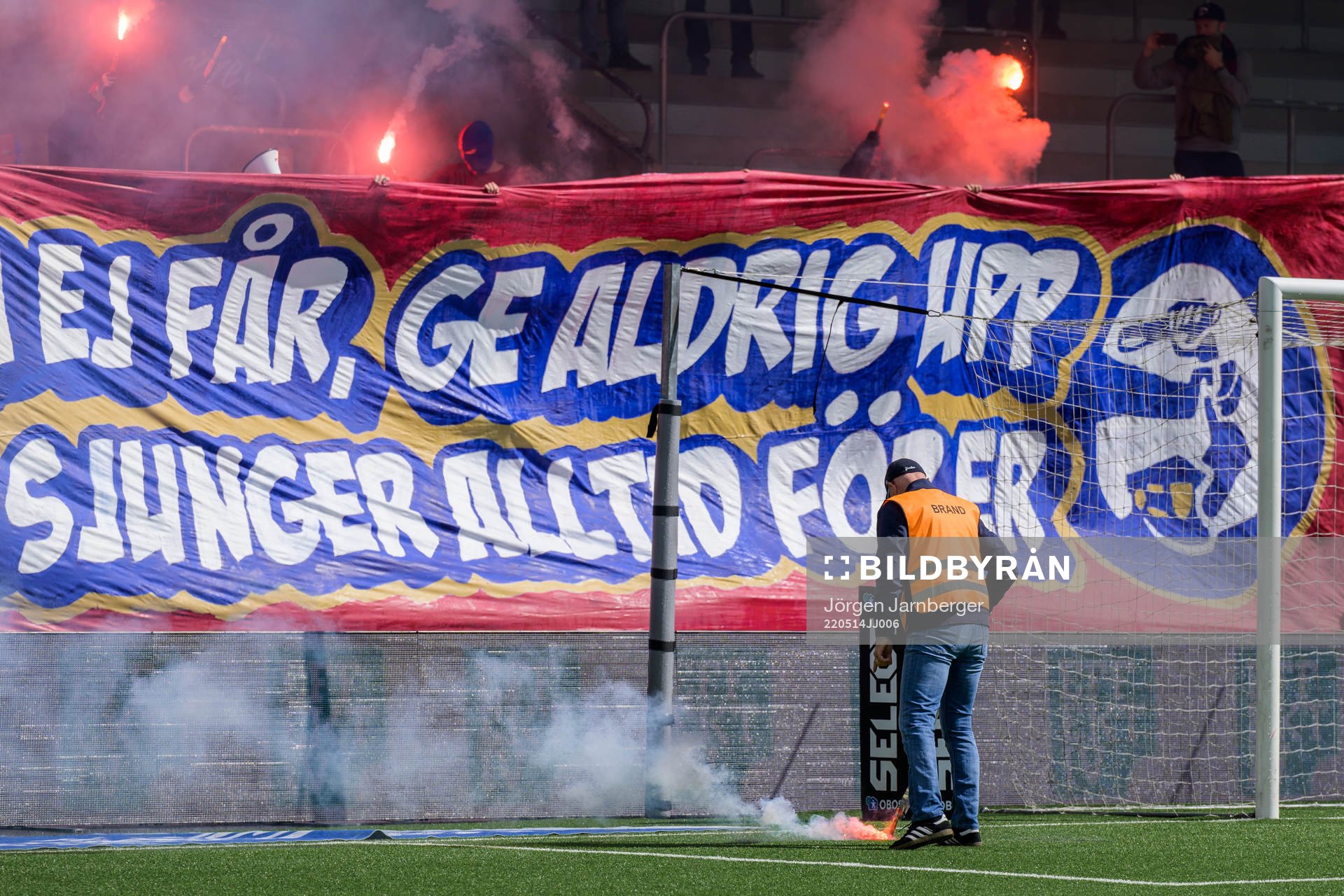 En funktionär plockar upp en bengal från planen