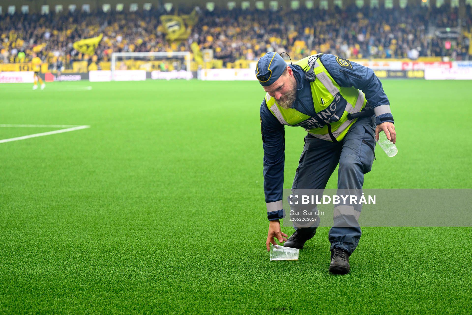 En ordningsvakt plockar upp inkastade föremål från planen under fotbollsmatchen i Allsvenskan mellan Elfsborg och IFK Göteborg den 22 maj 2022 i Borås.