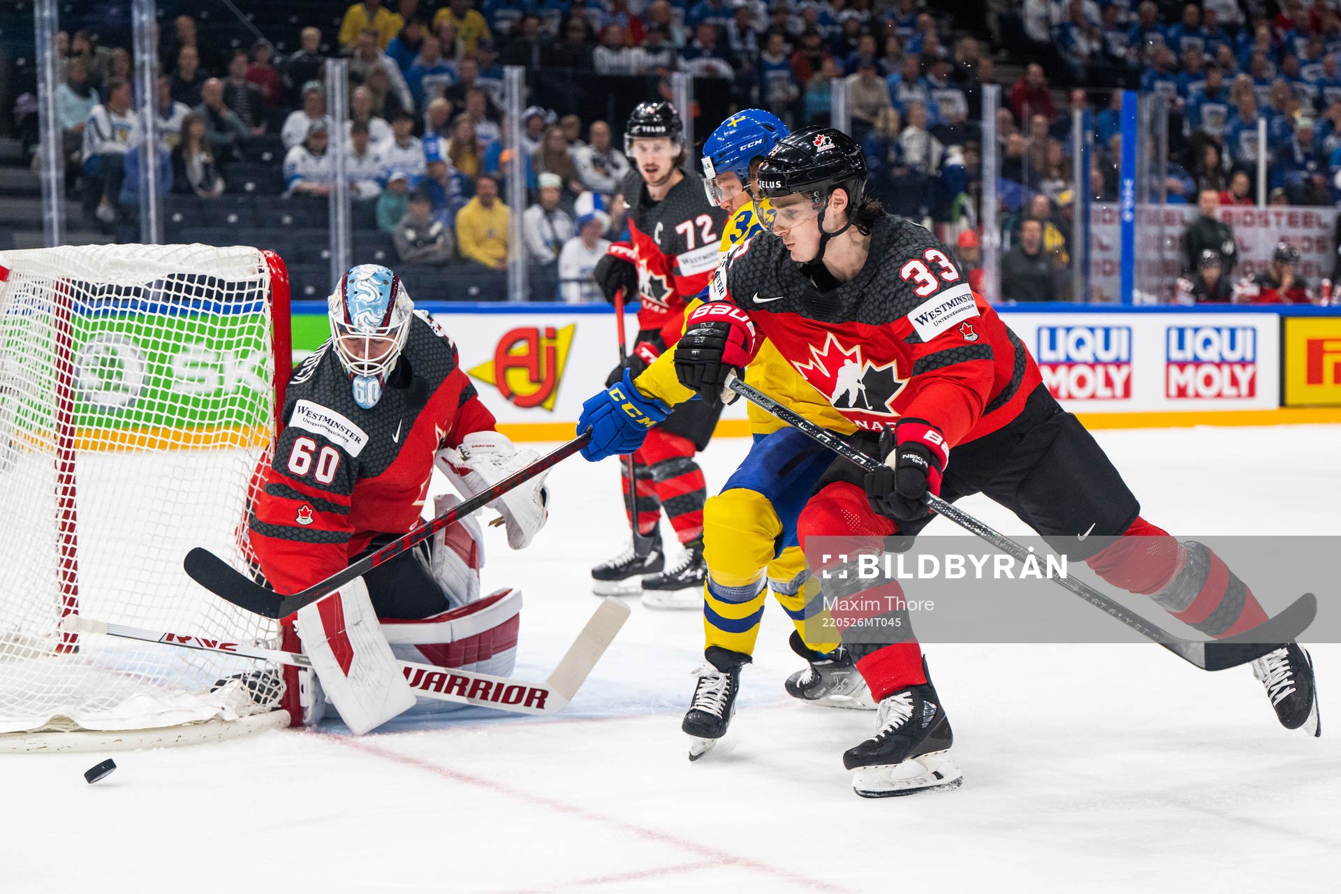 goaltender Chris Driedger and Ryan Graves of Canada defend
