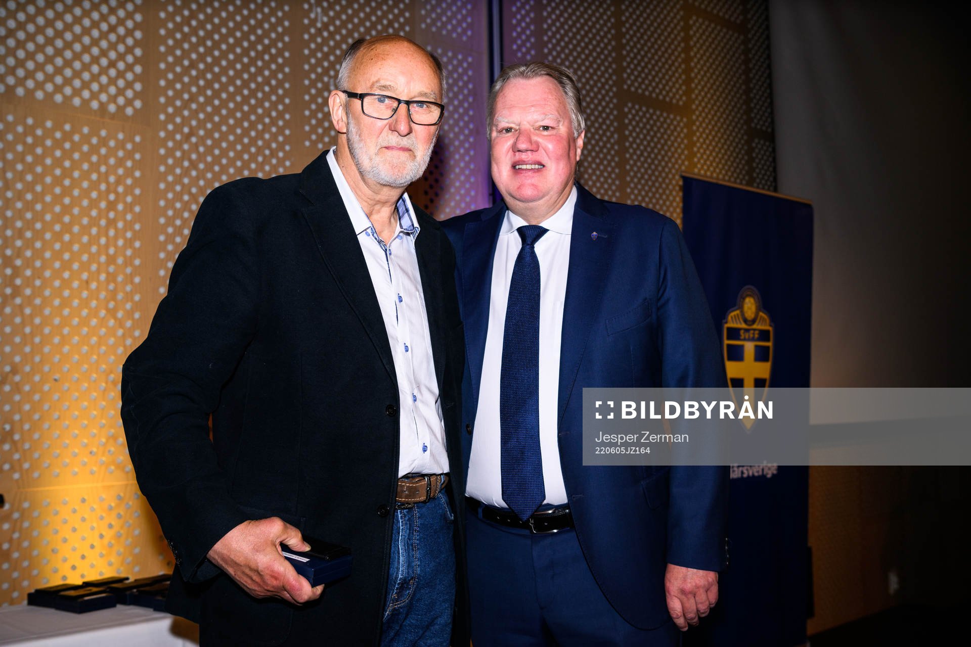 Carl Gustav Larsson tar emot ett förtjänsttecken i guld