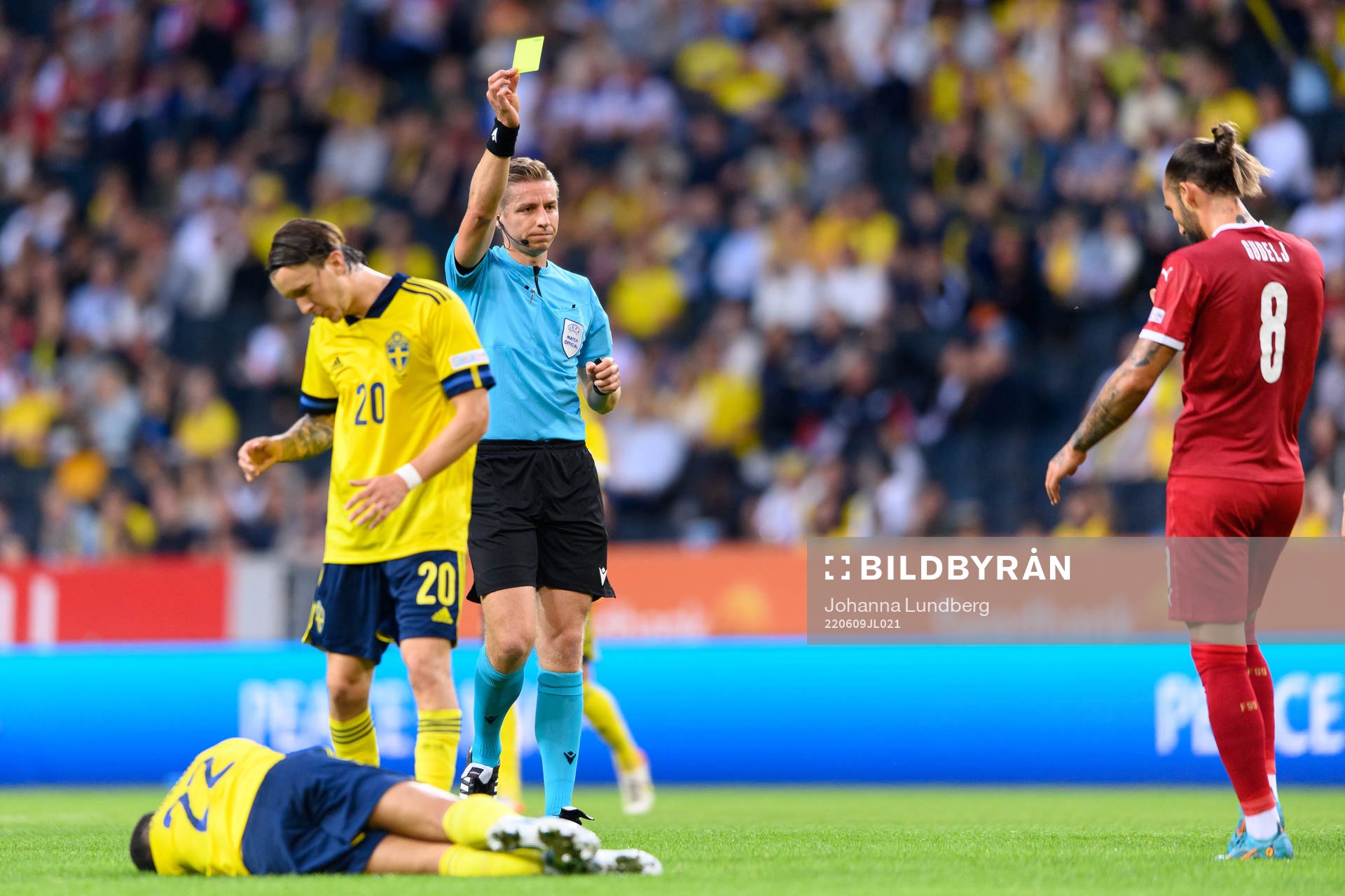 Referee Lawrence Visser shows a yellow card to Nemanja