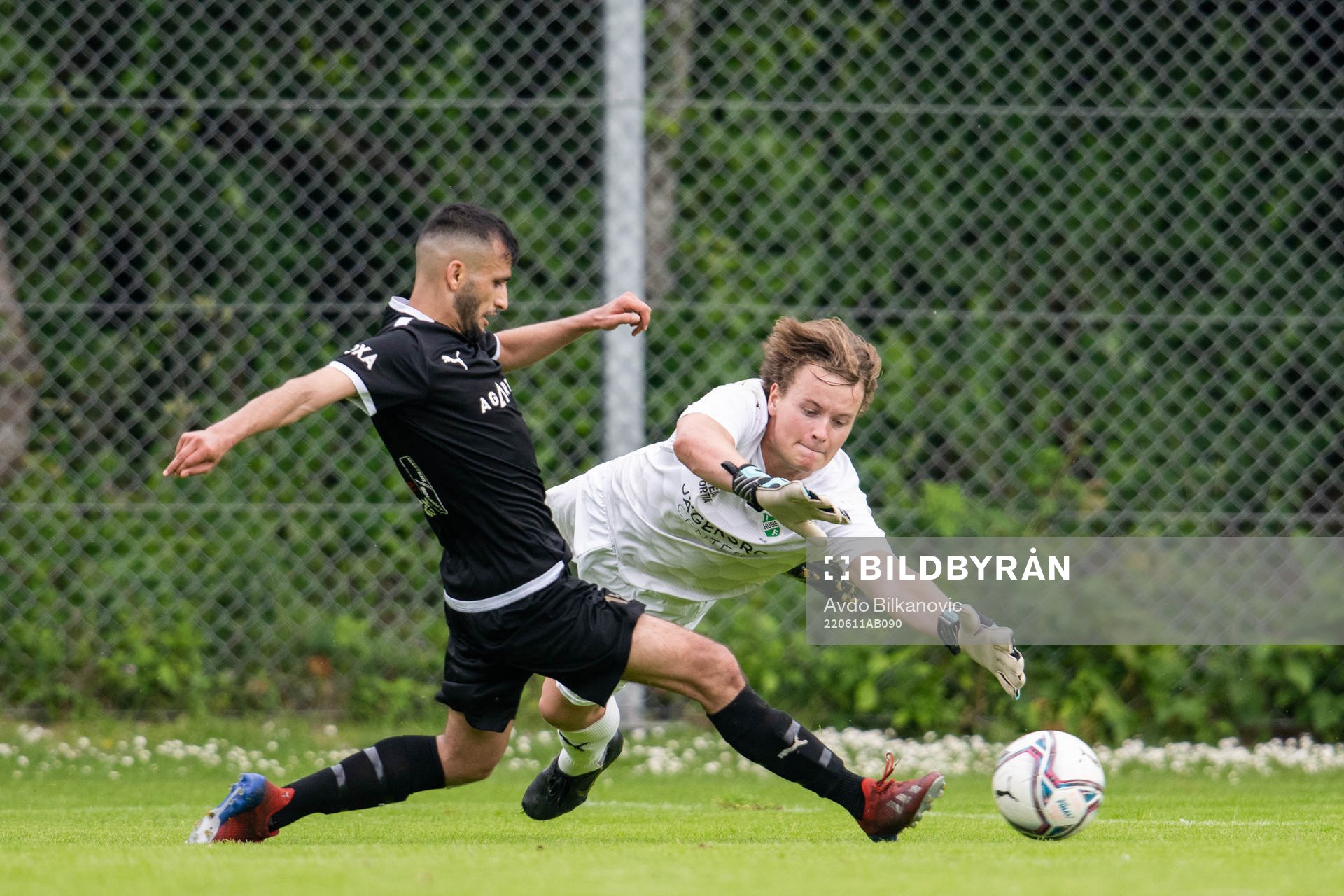 Husie målvakt Wilmer Magnusson och Bellevue Mirwais Yousufi under fotbollsmatchen i Div 4, Sydvästra Skåne, Herr, mellan Husie och Bellevue den 11 juni 2022 i Malmö. 