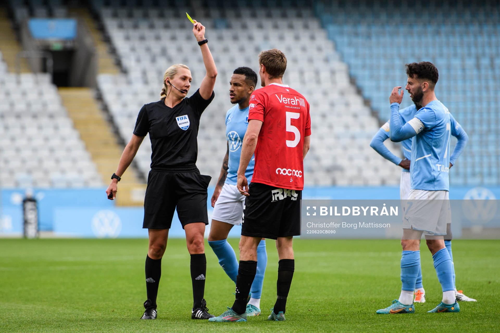domare Tess Olofsson visar ett gult kort till Malmö FFs Martin Olsson och Trelleborgs Anton Tideman under träningsmatchen i fotboll mellan Malmö FF och Trelleborg den 20 juni 2022 i Malmö.
