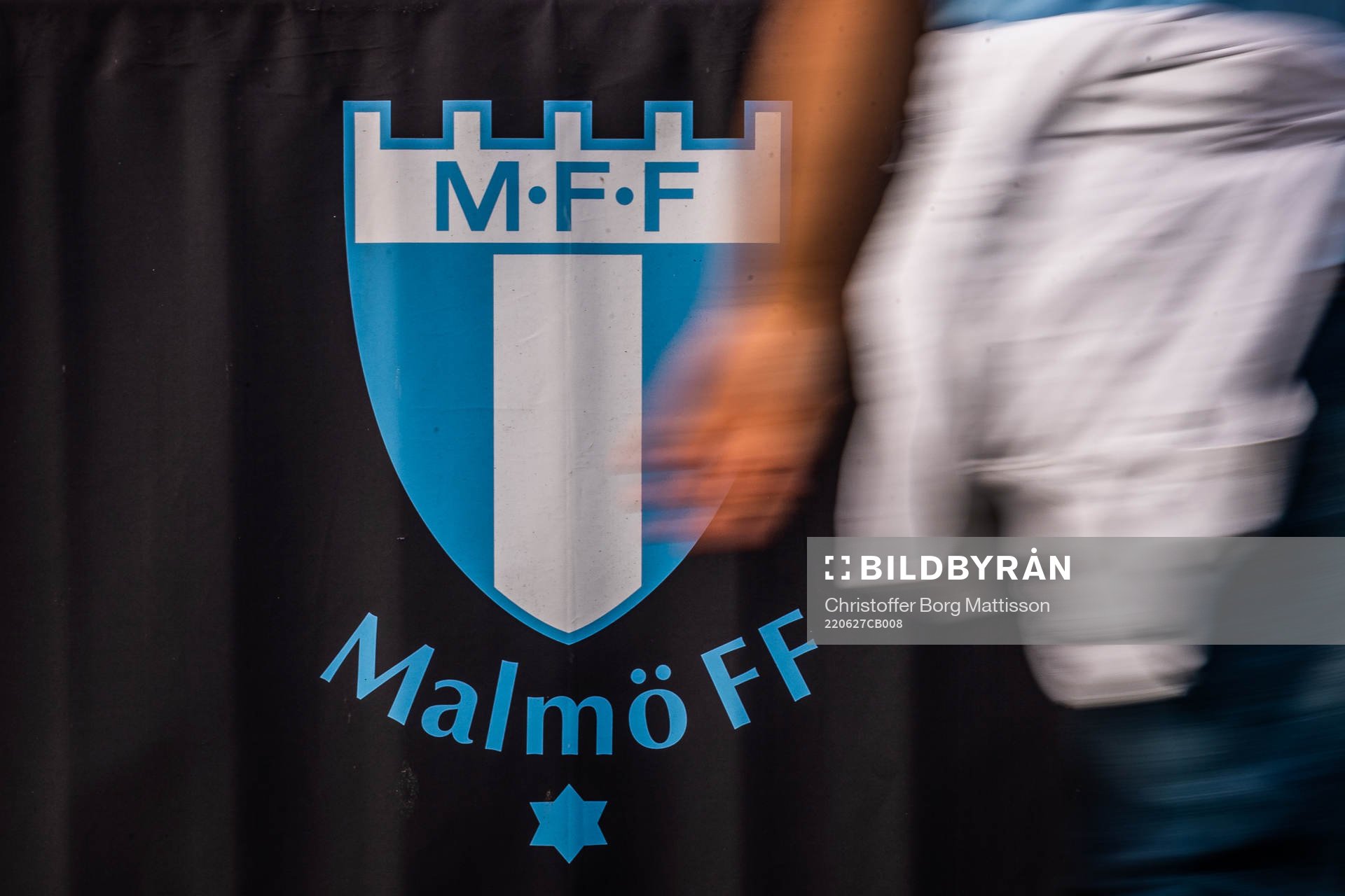 En person går förbi en Malmö FF-logotyp