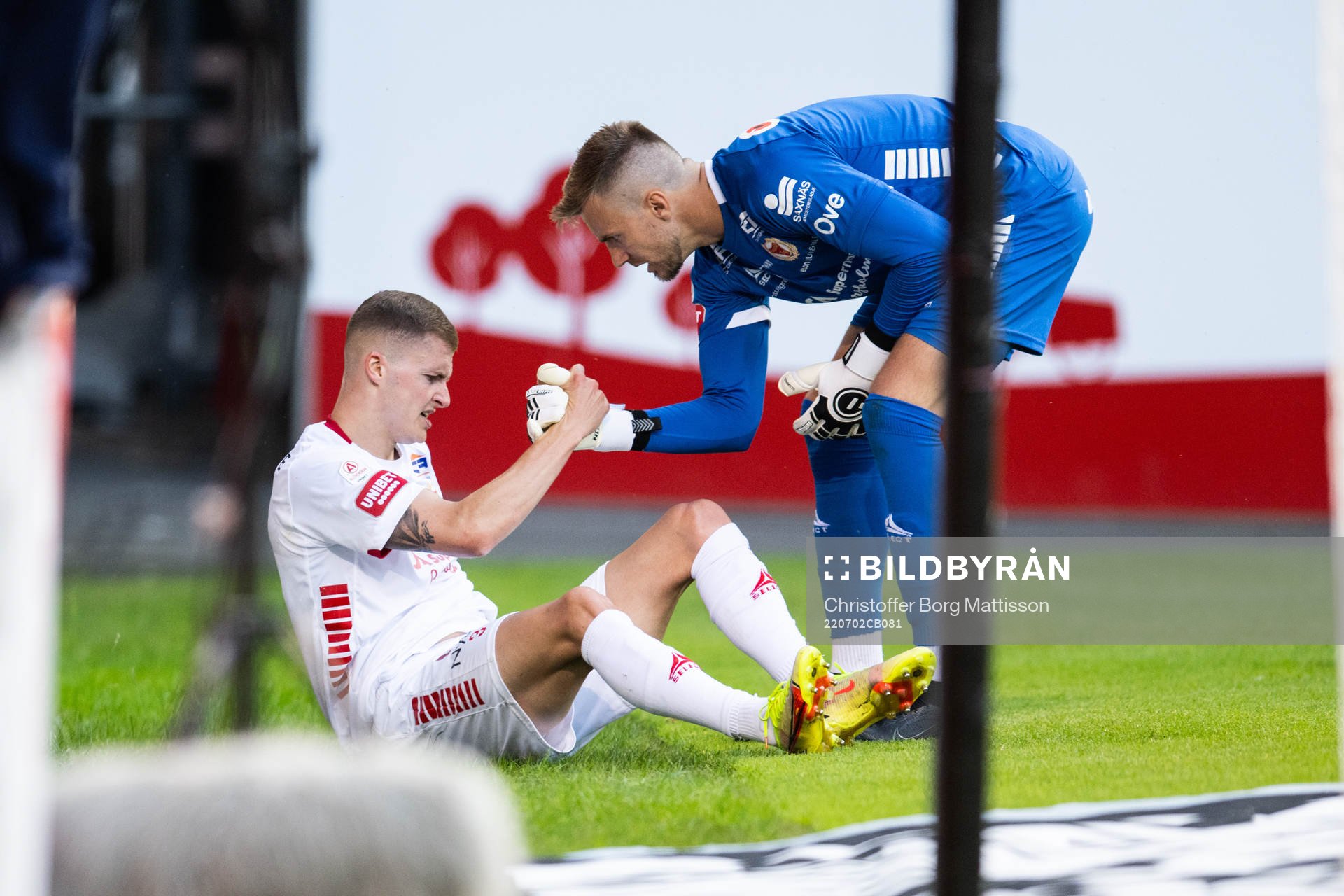 Kalmars Davíd Kristján Ólafsson har ont och får hjälp av målvakt Ricardo Friedrich under fotbollsmatchen i Allsvenskan mellan Helsingborg och Kalmar den 2 juli 2022 i Helsingborg.