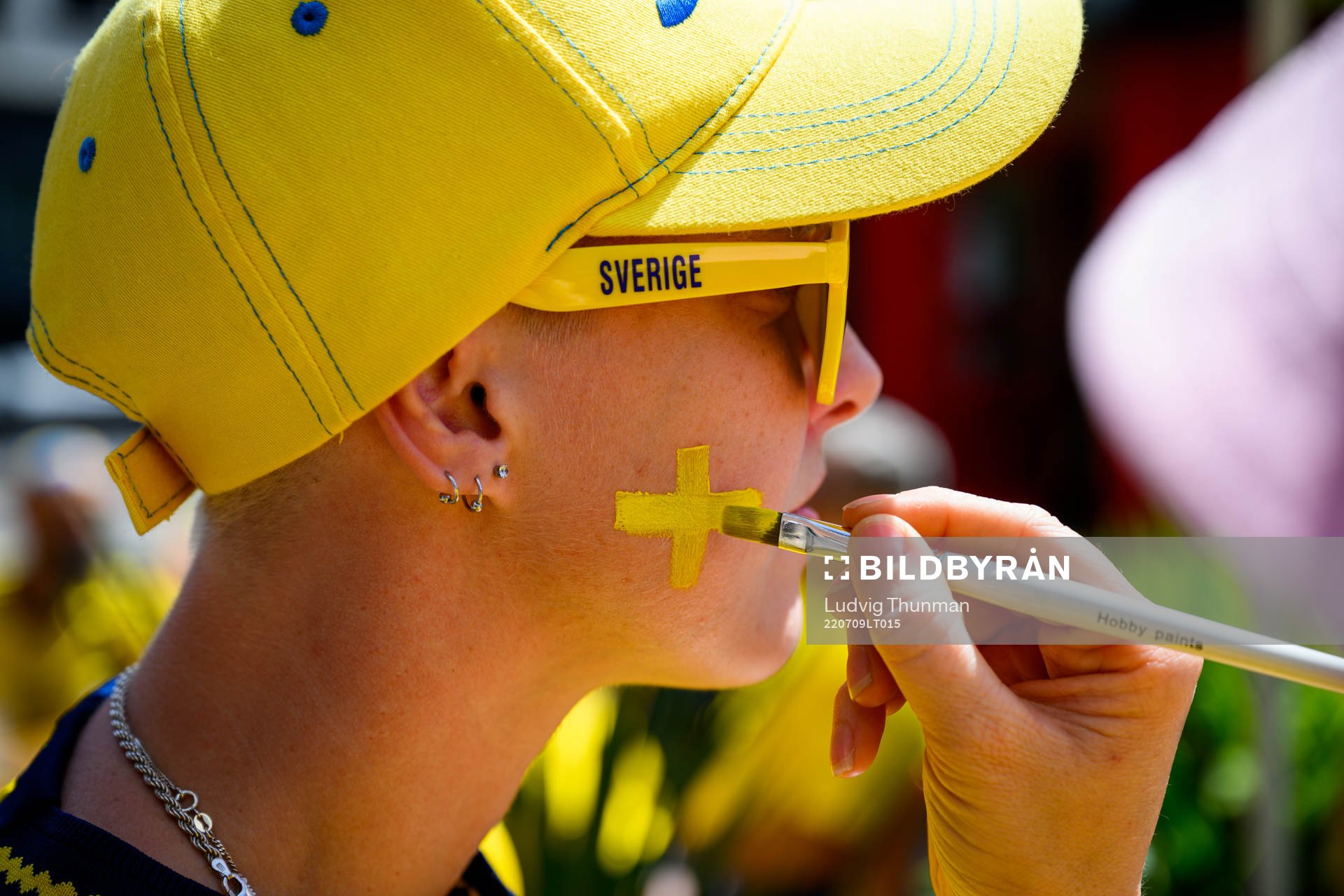 A supporter of Sweden gets the Swedish flag painted
