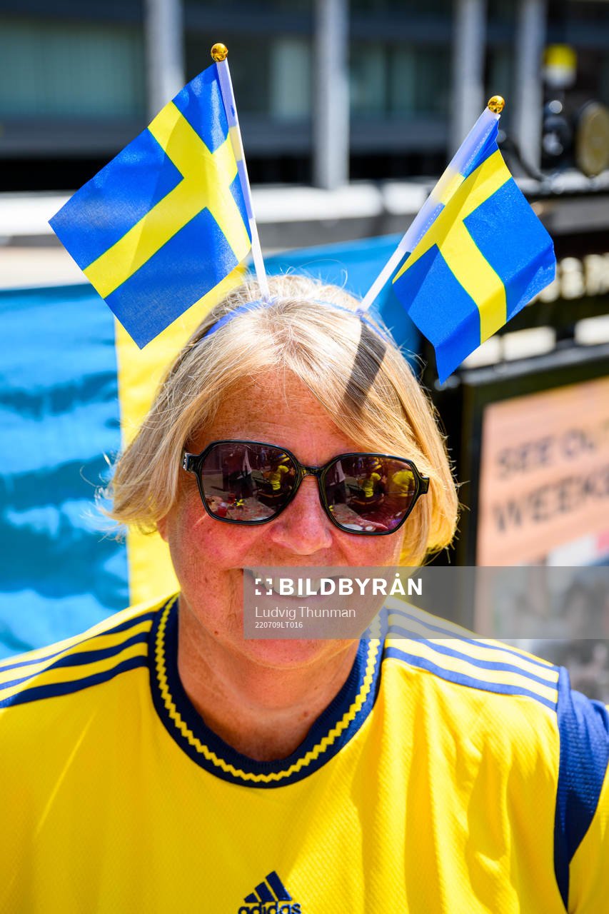 A supporter of Sweden with two Swedish flags in downtown