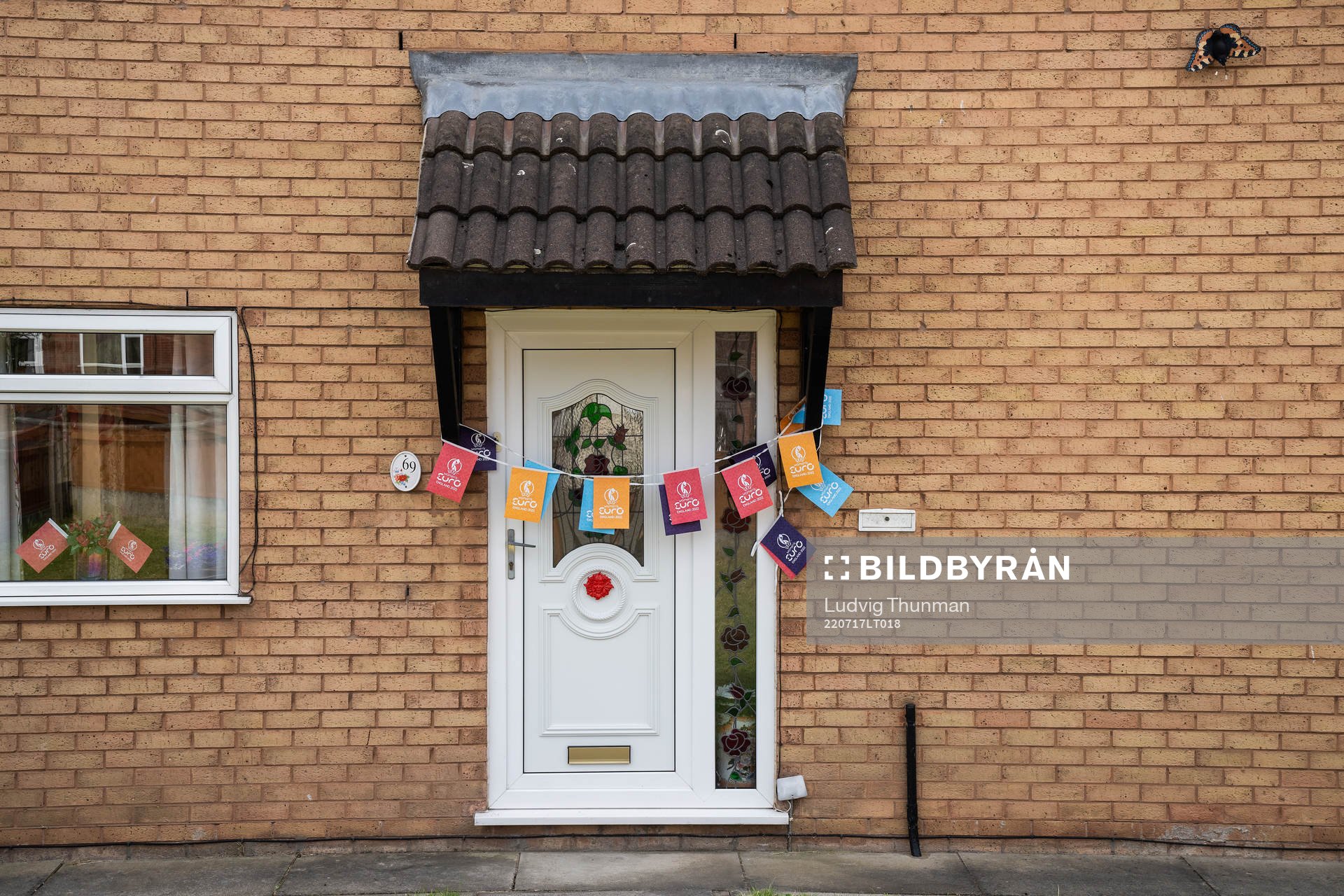 A front door decorated with Euro 2022 flags