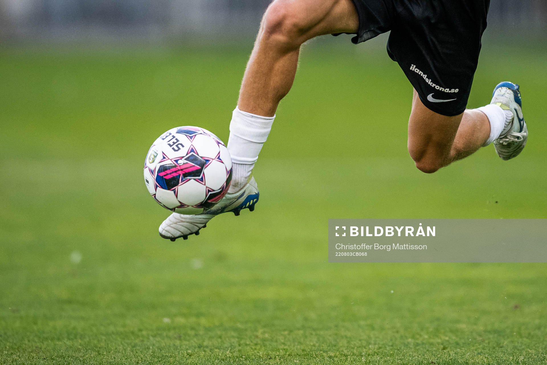 En fotbollsspelare springer med bollen