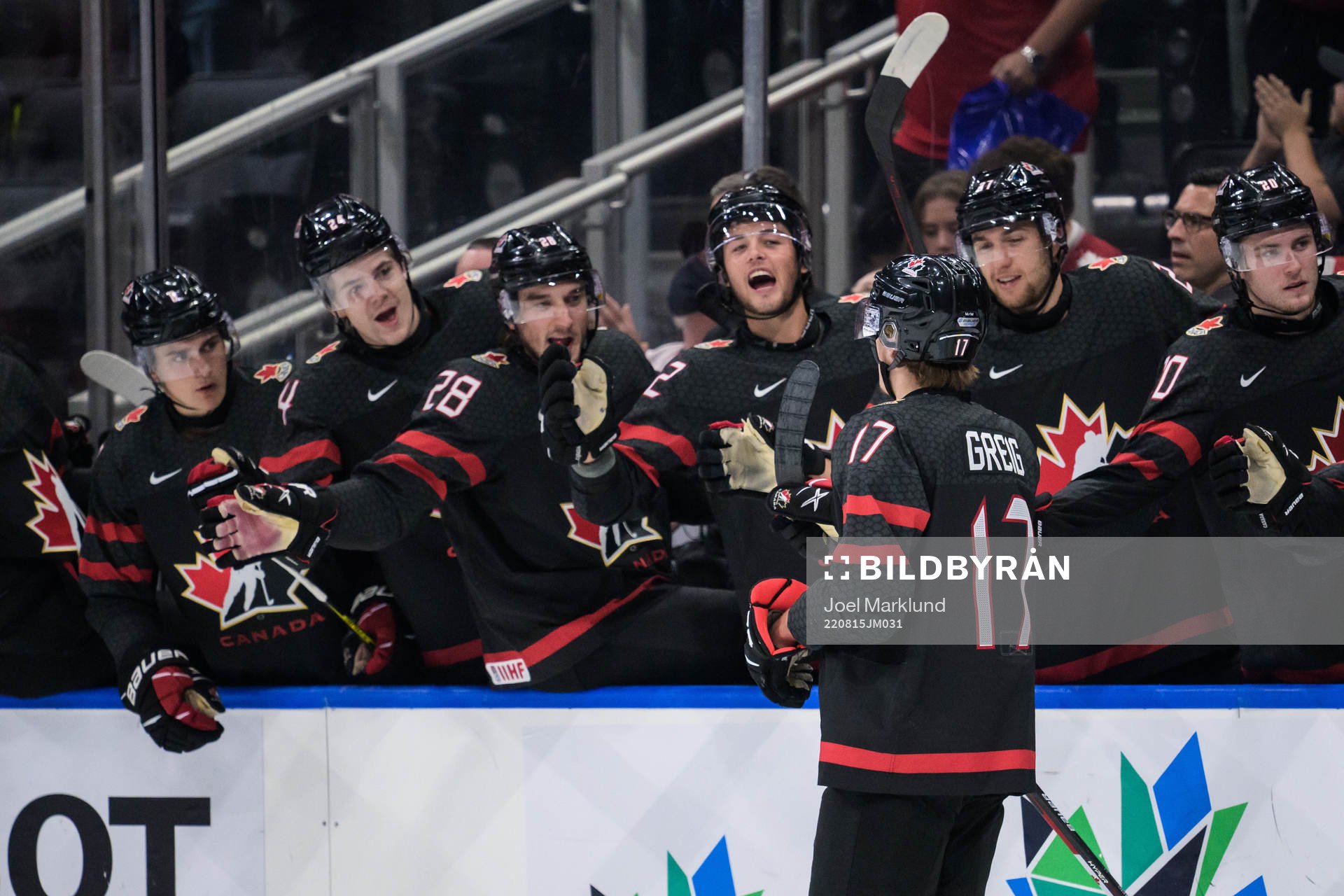 Ridly Greig of Canada celebrates with teammates