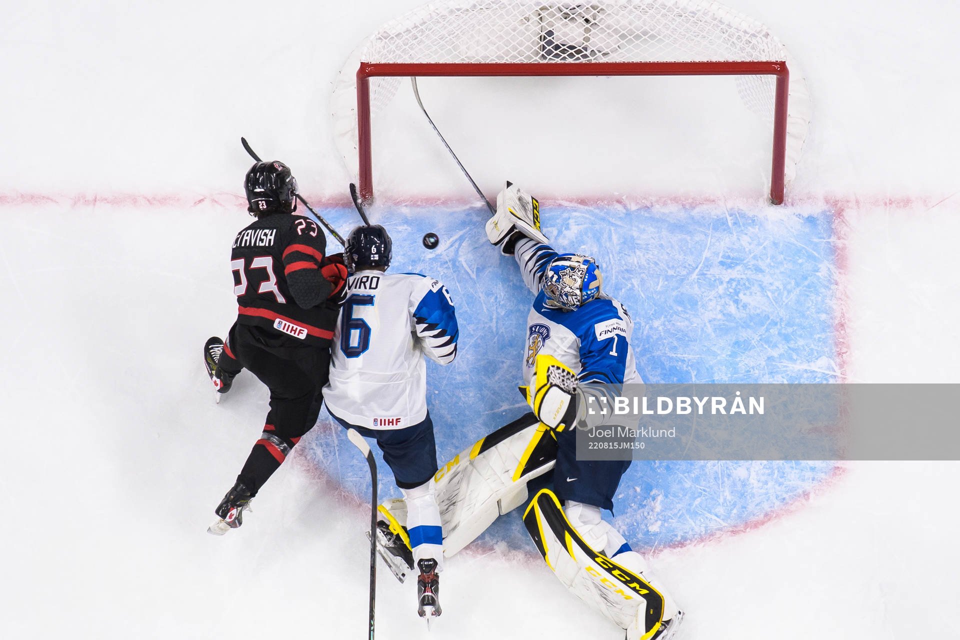 Mason McTavish of Canada challenges Eemil Viro and
