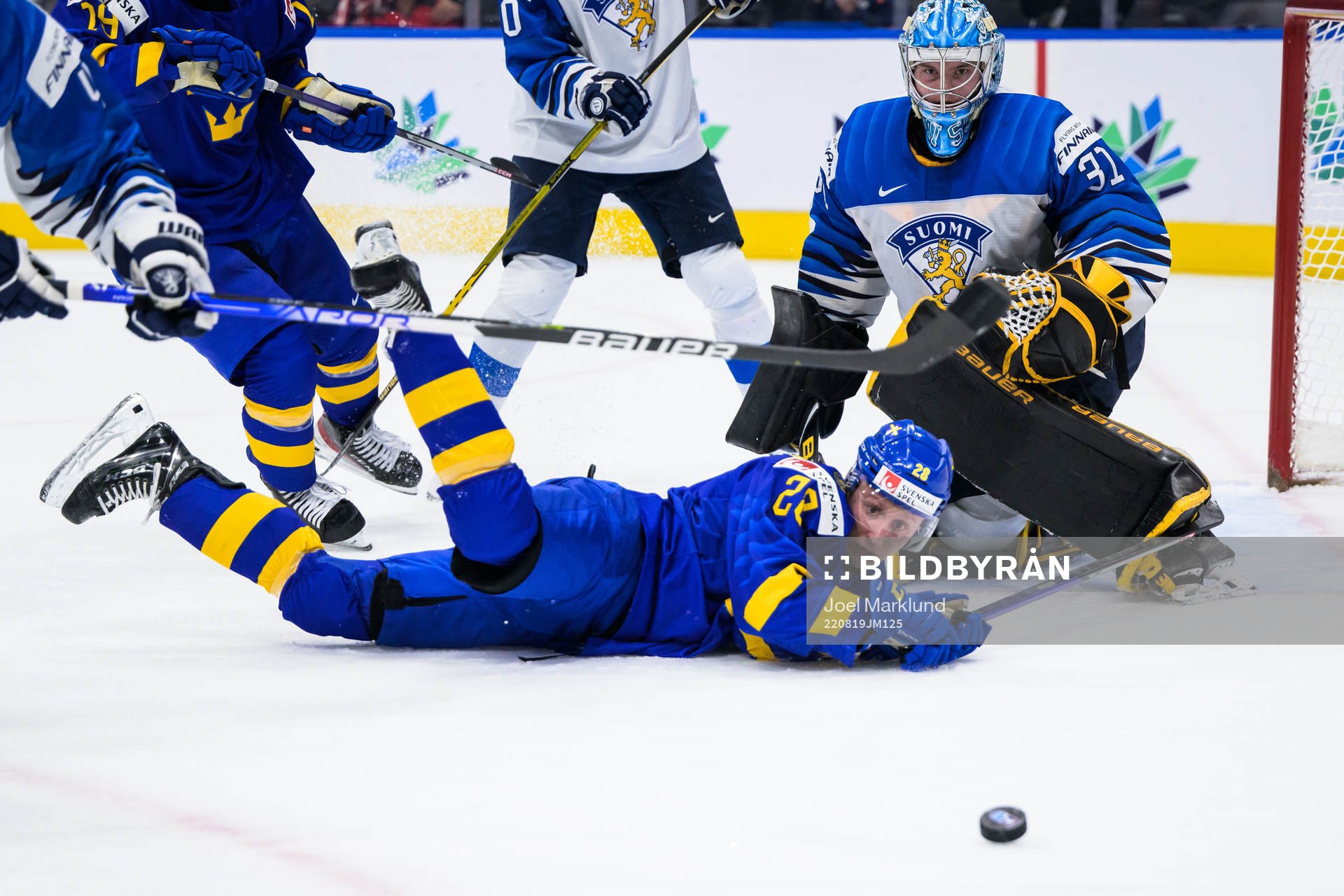 Oskar Magnusson of Sweden trips in front of goaltender Juha