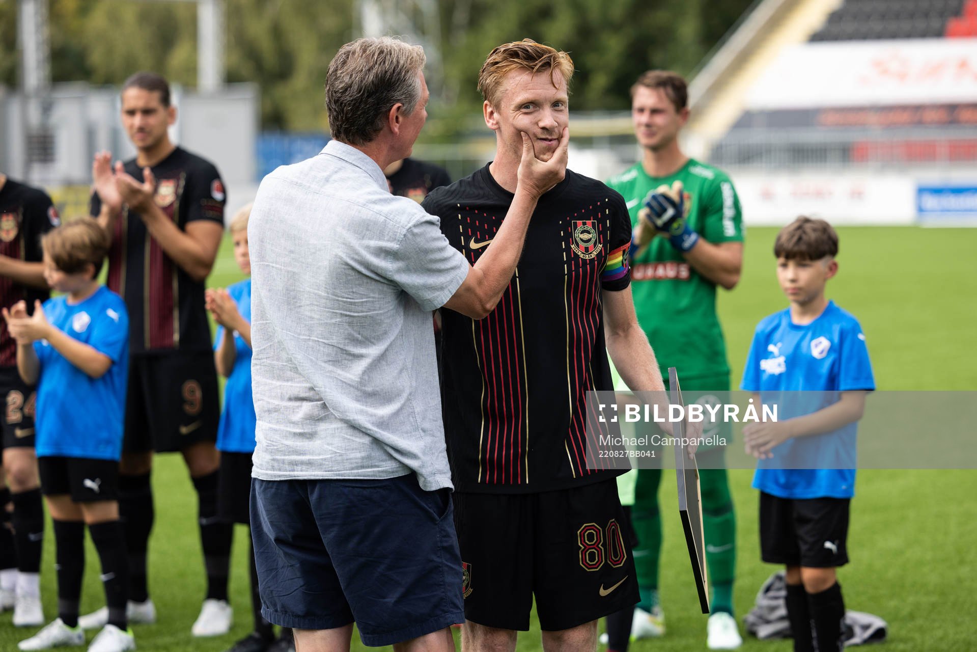 Berndt Magnusson ger en tavla till sin son Gustav Sandberg Magnusson för flest matcher genom tiderna för Brommapojkarna inför fotbollsmatchen i Superettan mellan Brommapojkarna och Halmstad den 27 augusti 2022 i Stockholm.