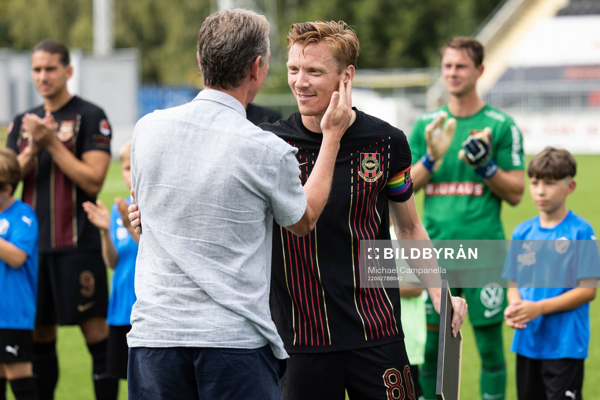 Berndt Magnusson ger en tavla till sin son Gustav Sandberg Magnusson för flest matcher genom tiderna för Brommapojkarna inför fotbollsmatchen i Superettan mellan Brommapojkarna och Halmstad den 27 augusti 2022 i Stockholm.