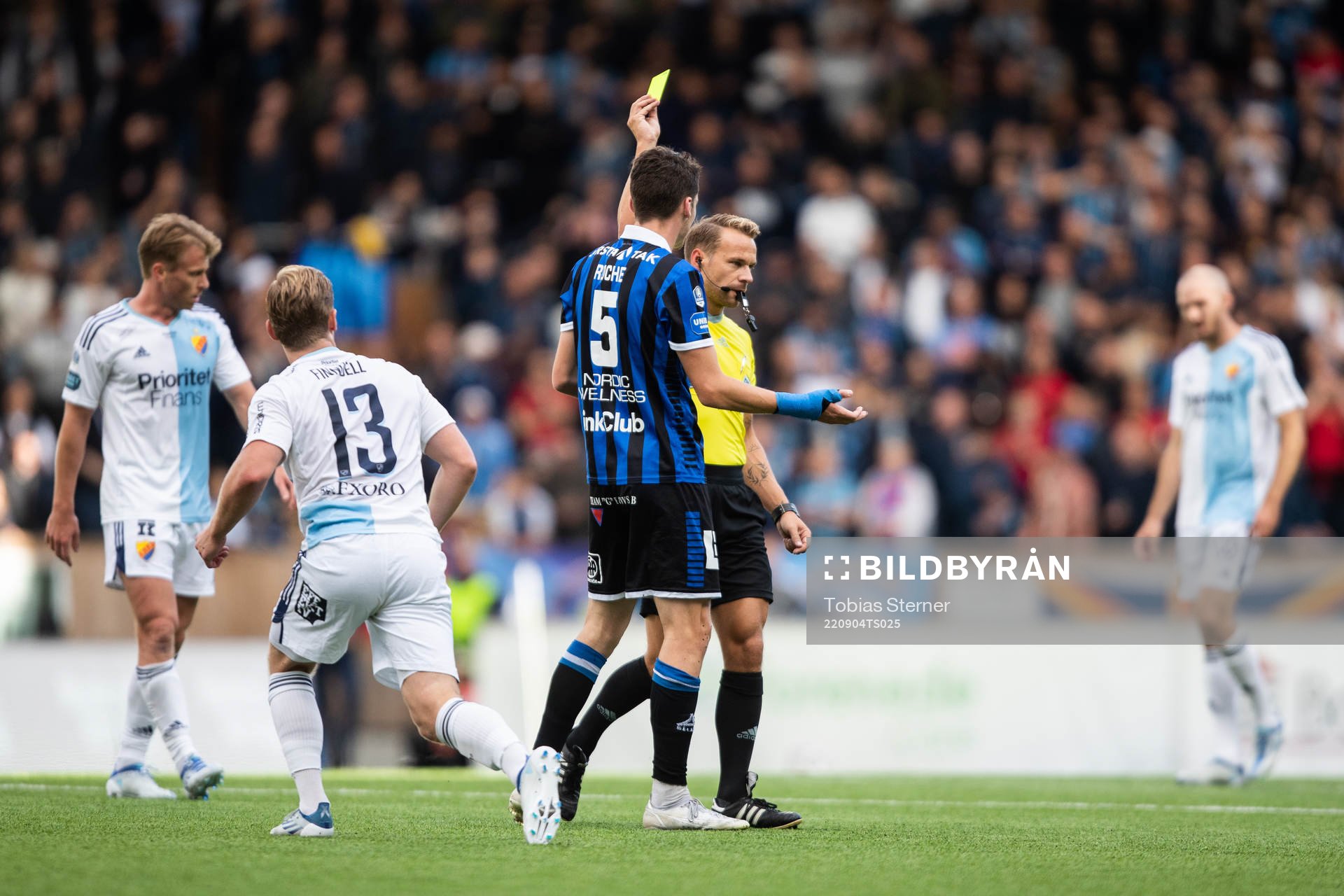 Domare Kristoffer Karlsson delar ut ett gult kort till
