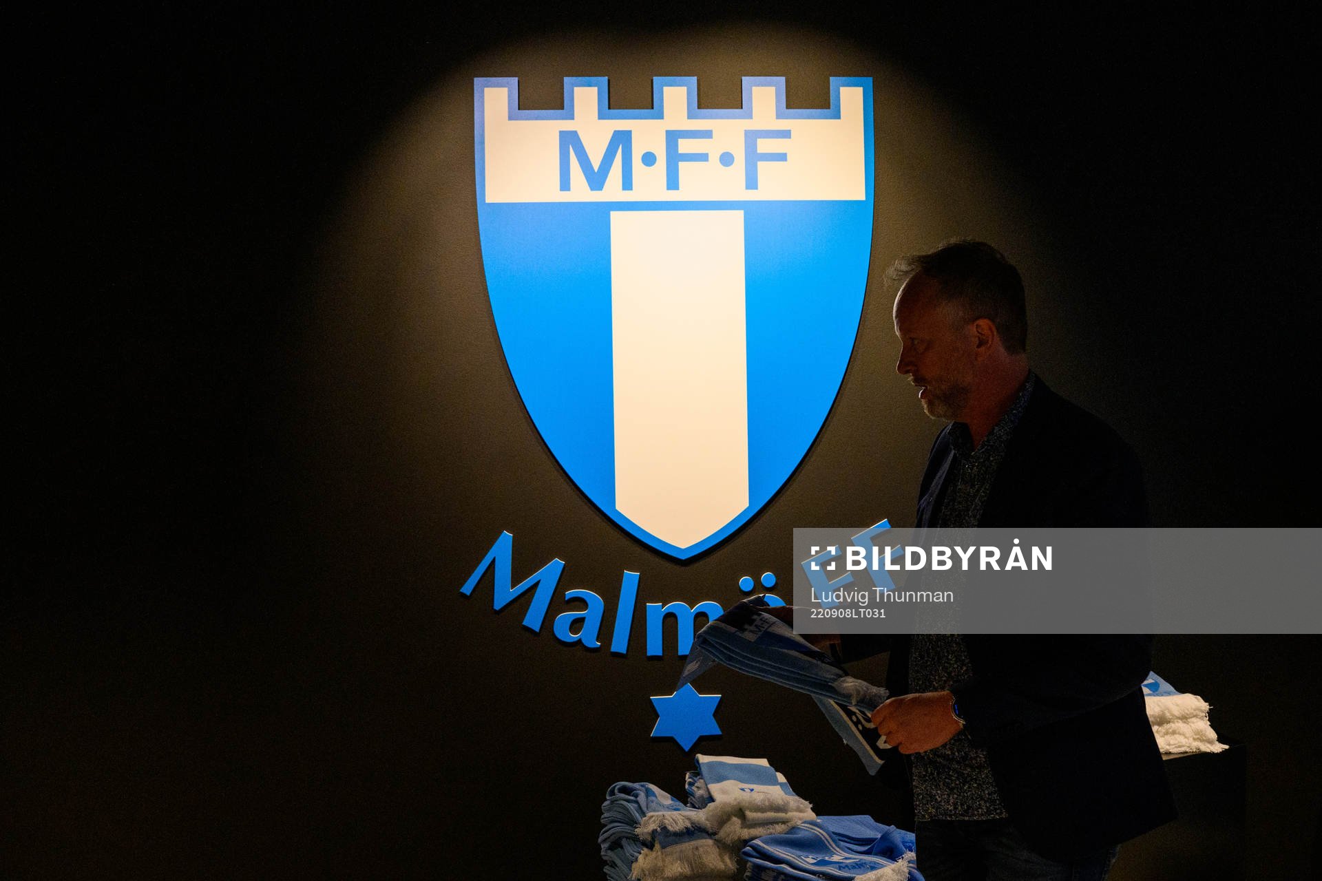 A man looks at scarfs in the supporter shop in front of the