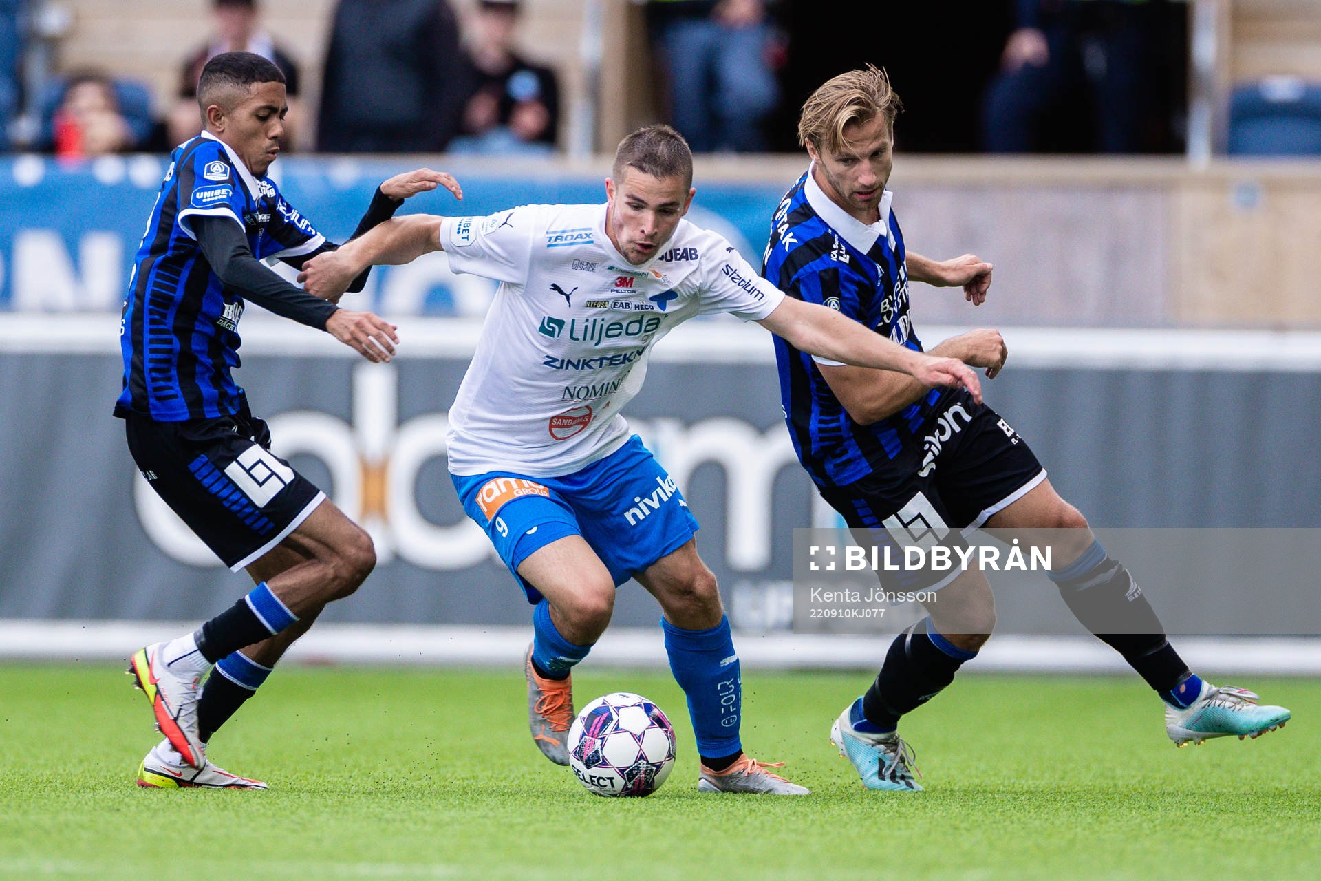 Värnamos Oscar Johansson i kamp med Sirius Tashreeq Matthews och Daniel Stensson under fotbollsmatchen i Allsvenskan mellan Sirius och Värnamo den 10 september 2022 i Uppsala. 