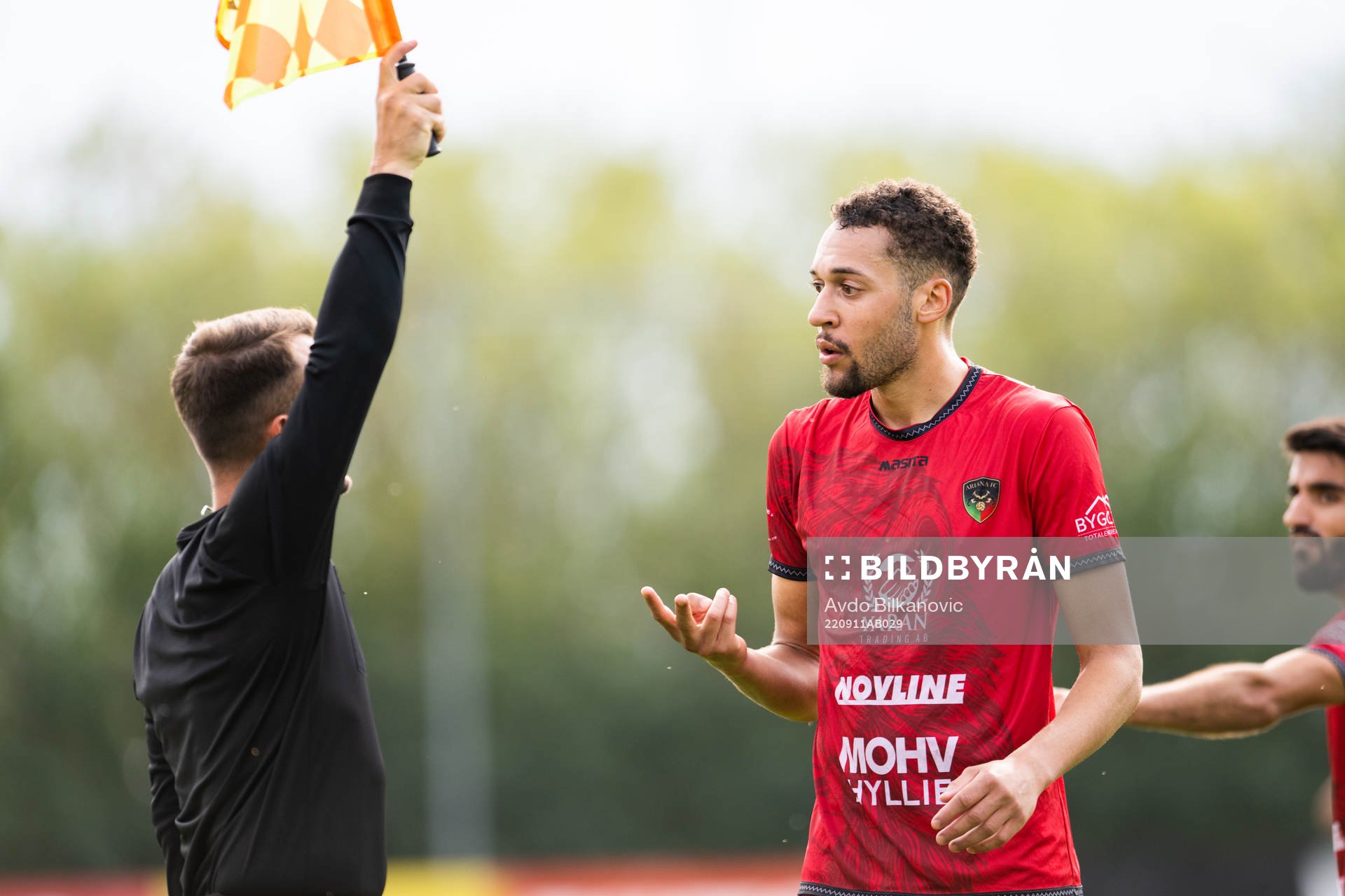 Arianas Patchicco Diallo och assisterande domare Faruk Camo under fotbollsmatchen i div.2 mellan Ariana och Balkan den 11 september 2022 i Malmö.