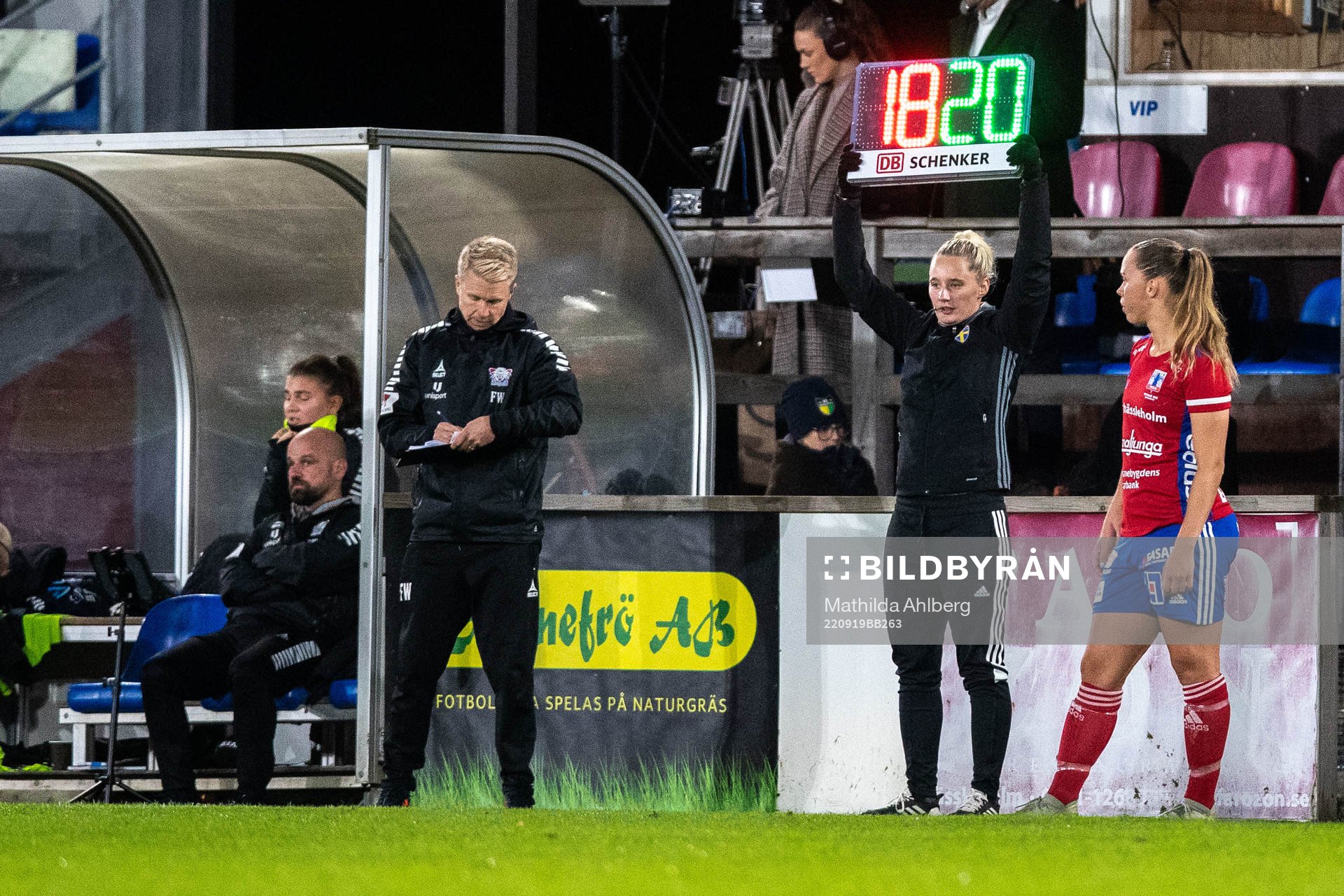 Fjärdedomare Isabelle Svensson visar upp tavla med siffror