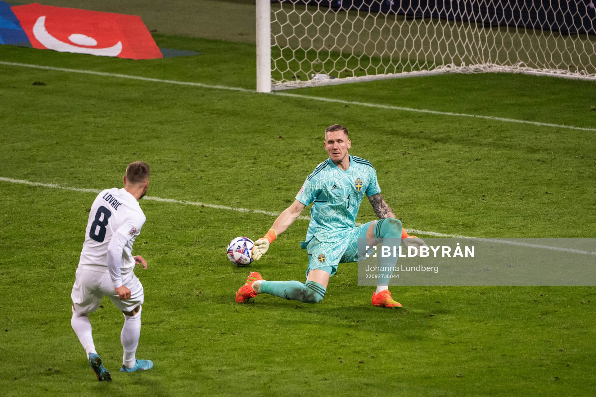 Sandi Lovric of Slovenia and goalkeeper Robin Olsen of