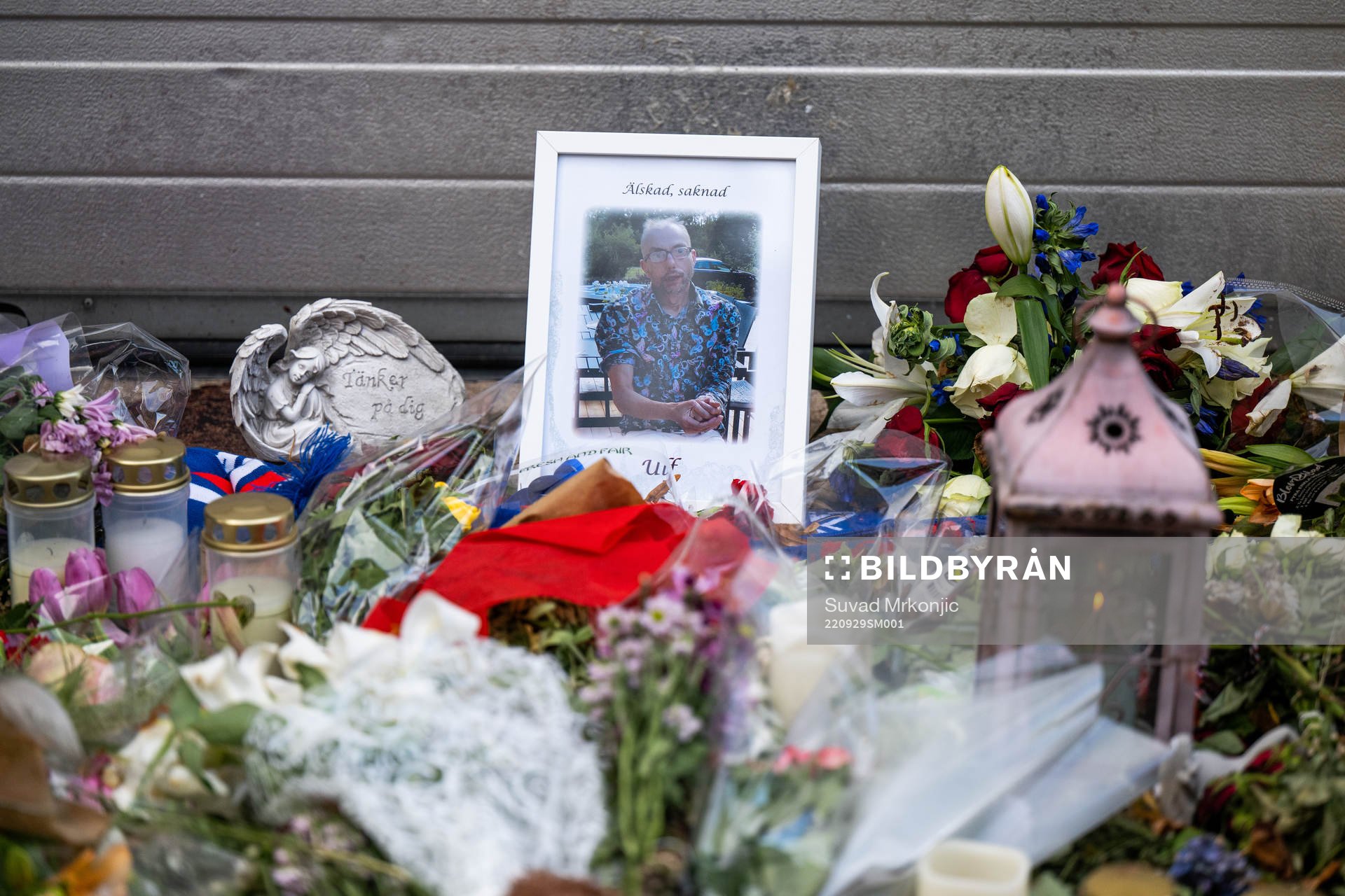 Blommor och ljus ligger på platsen där Ulf Sandberg