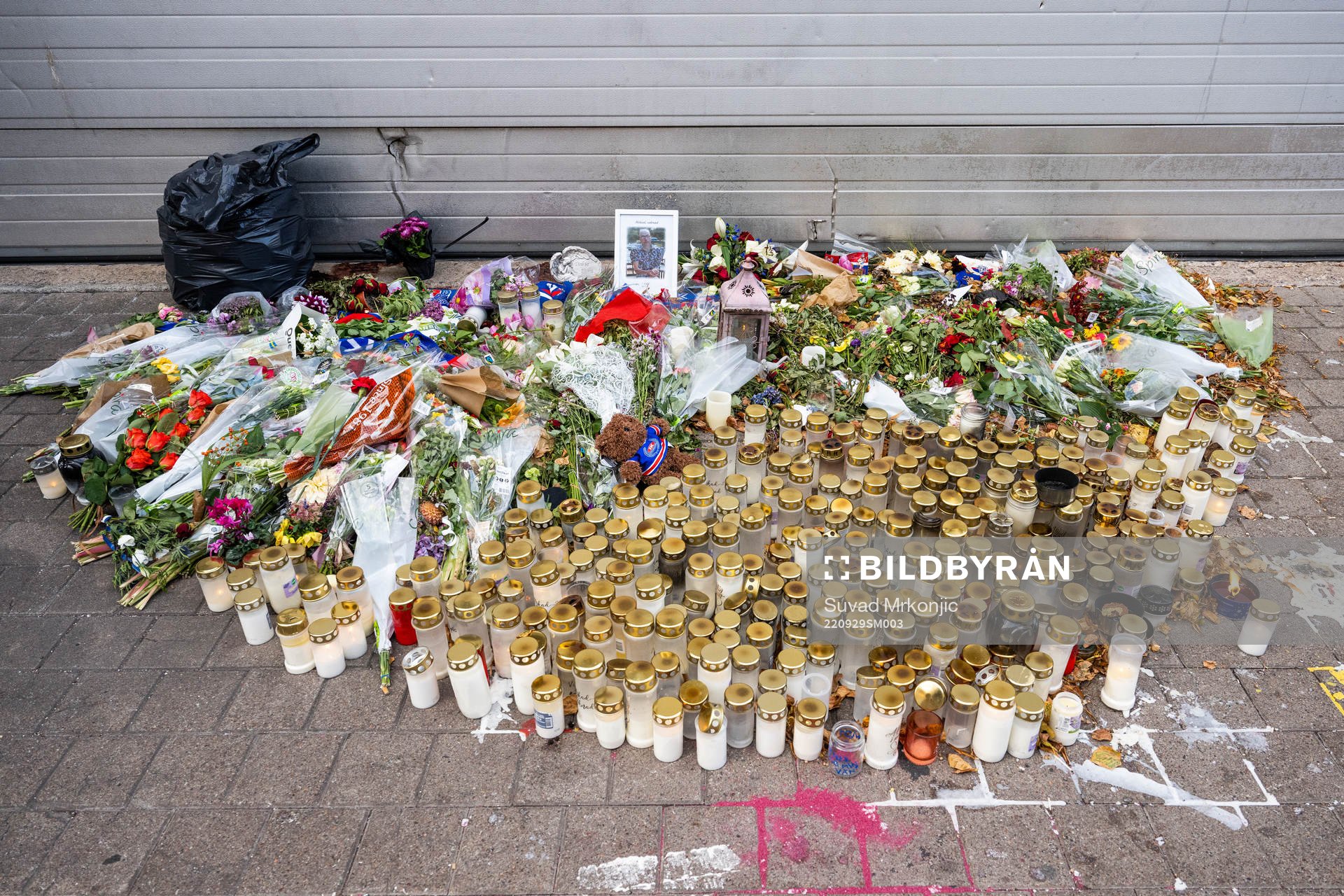 Blommor och ljus ligger på platsen där Ulf Sandberg