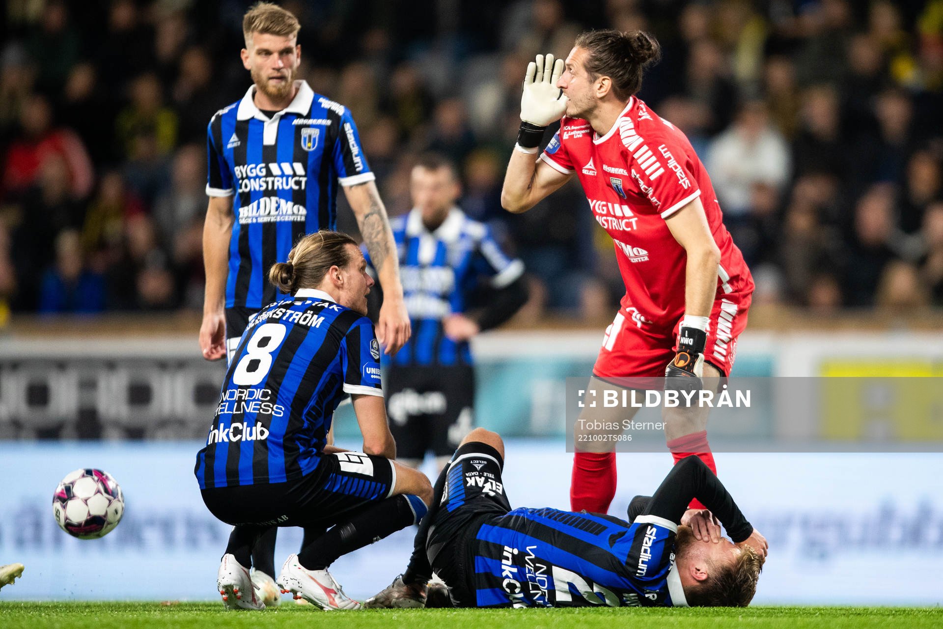 Sirius Dennis Widgren har ont och kollas till av Tim Björkström och målvakt David Mitov Nilsson under fotbollsmatchen i Allsvenskan mellan Sirius och AIK den 2 oktober 2022 i Uppsala.