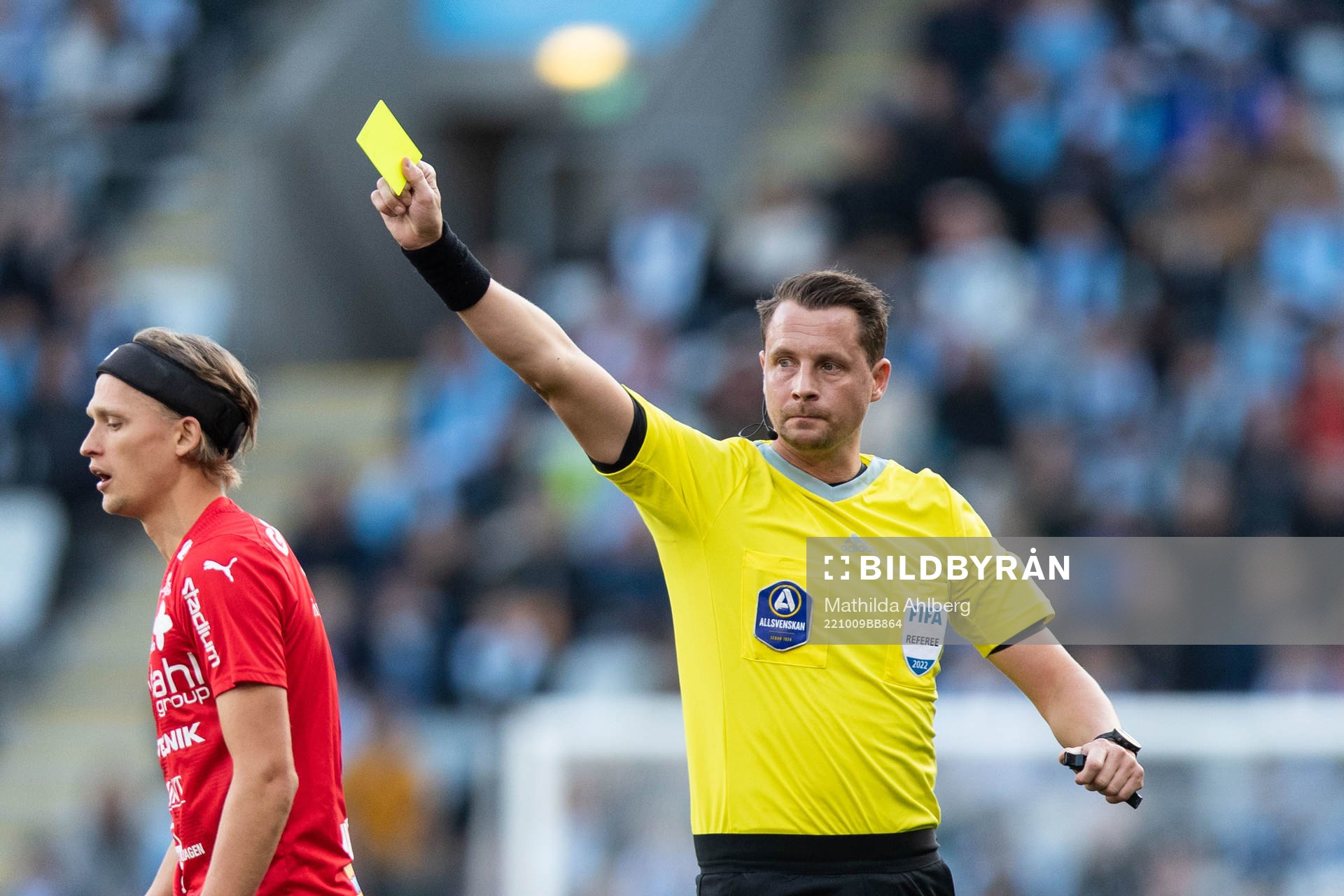 Domare Andreas Ekberg delar ut gult kort till Värnamos