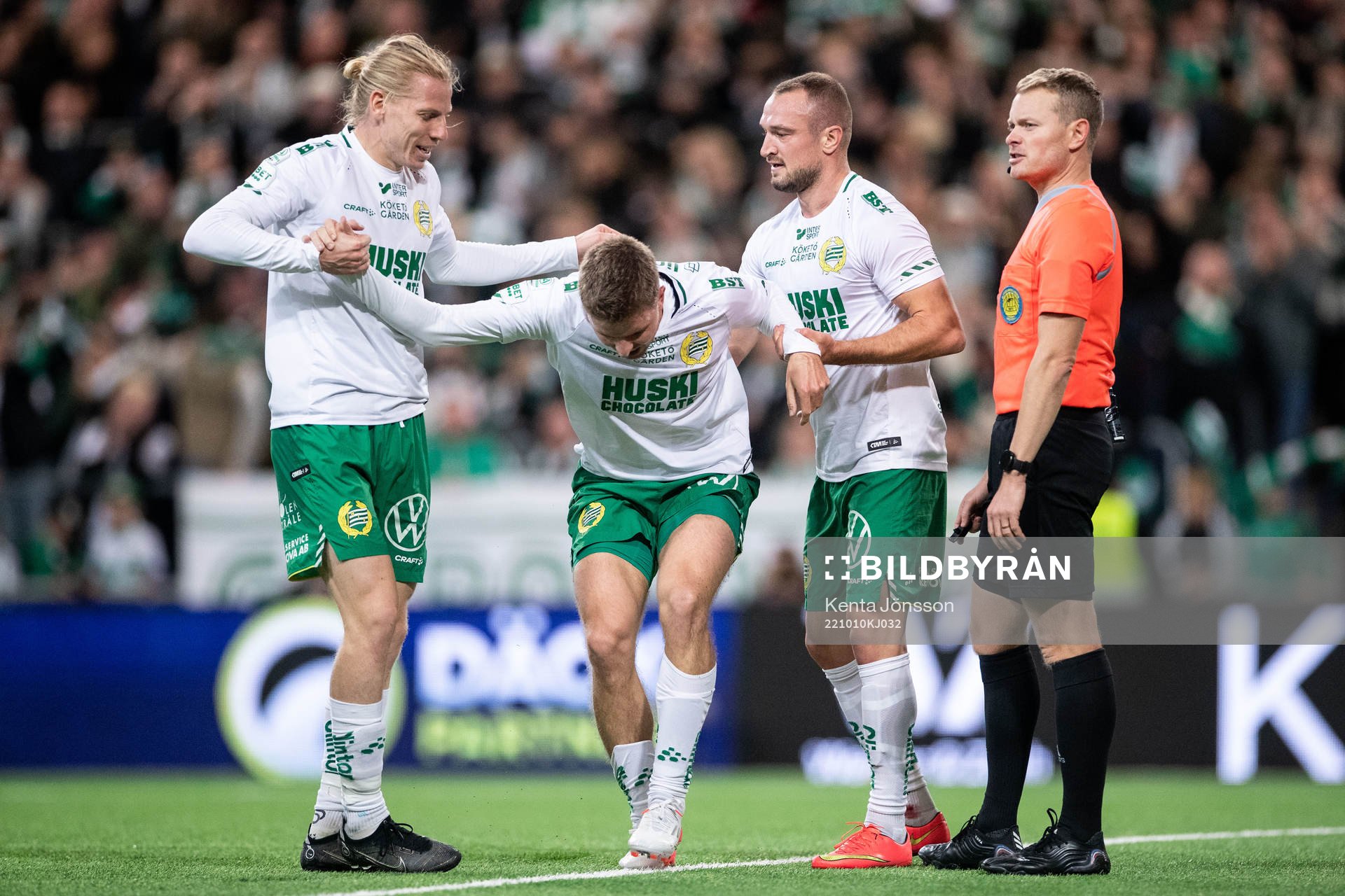 Hammarbys Joel Nilsson har ont och stöttas av Gustav Ludwigson och Veton Berisha under fotbollsmatchen i Allsvenskan mellan Hammarby och Varberg den 10 oktober 2022 i Stockholm.