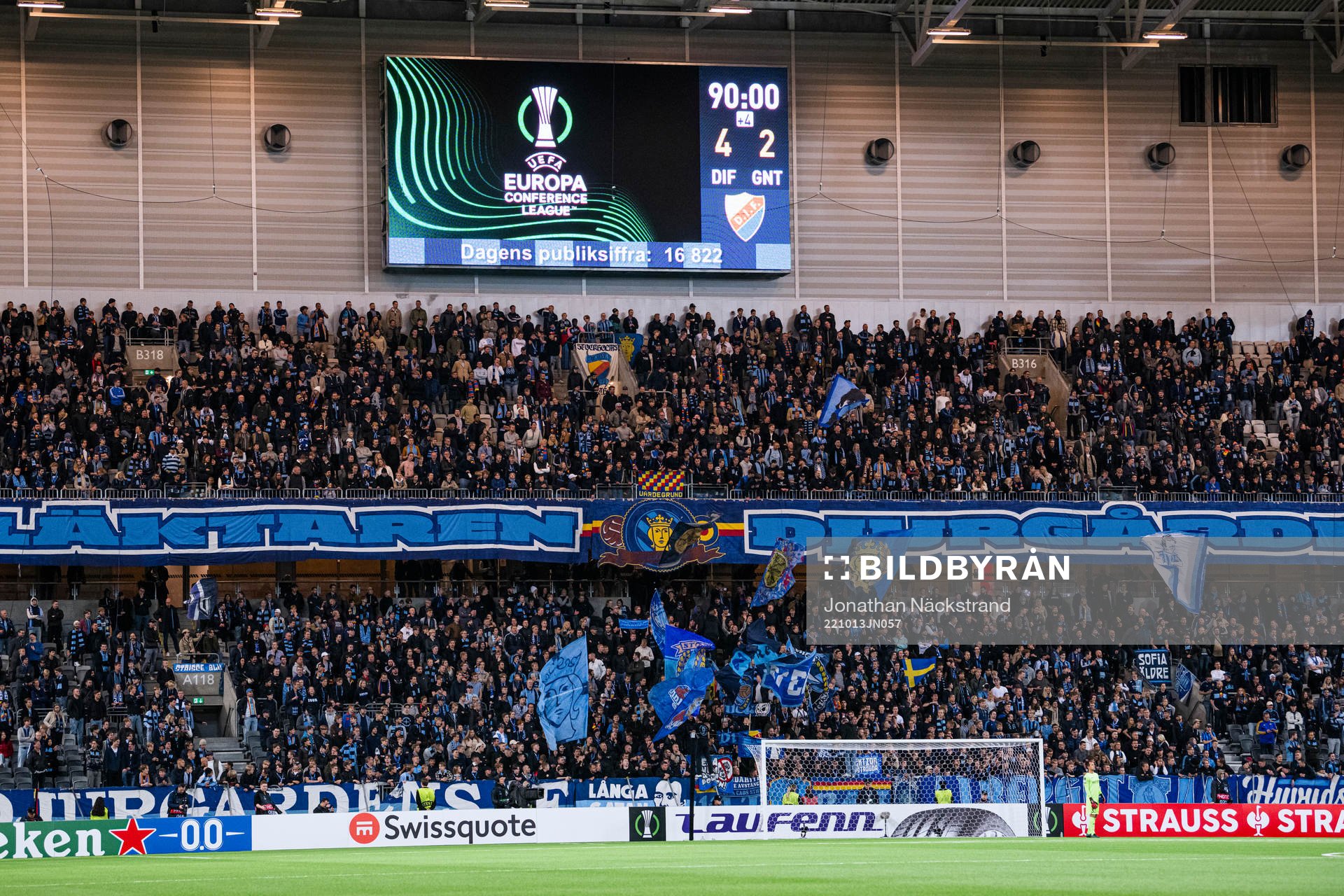 A big display shows the score behind the supporters of