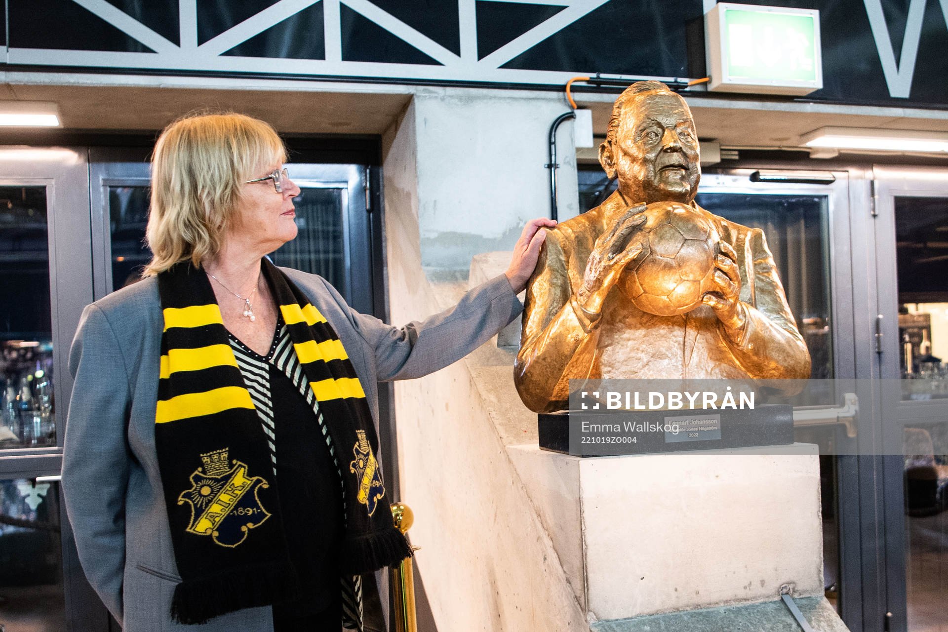 Eva Jansson med en minnesskulptur av Lennart Johansson inför fotbollsmatchen i Allsvenskan mellan AIK och Häcken den 19 oktober 2022 i Stockholm.