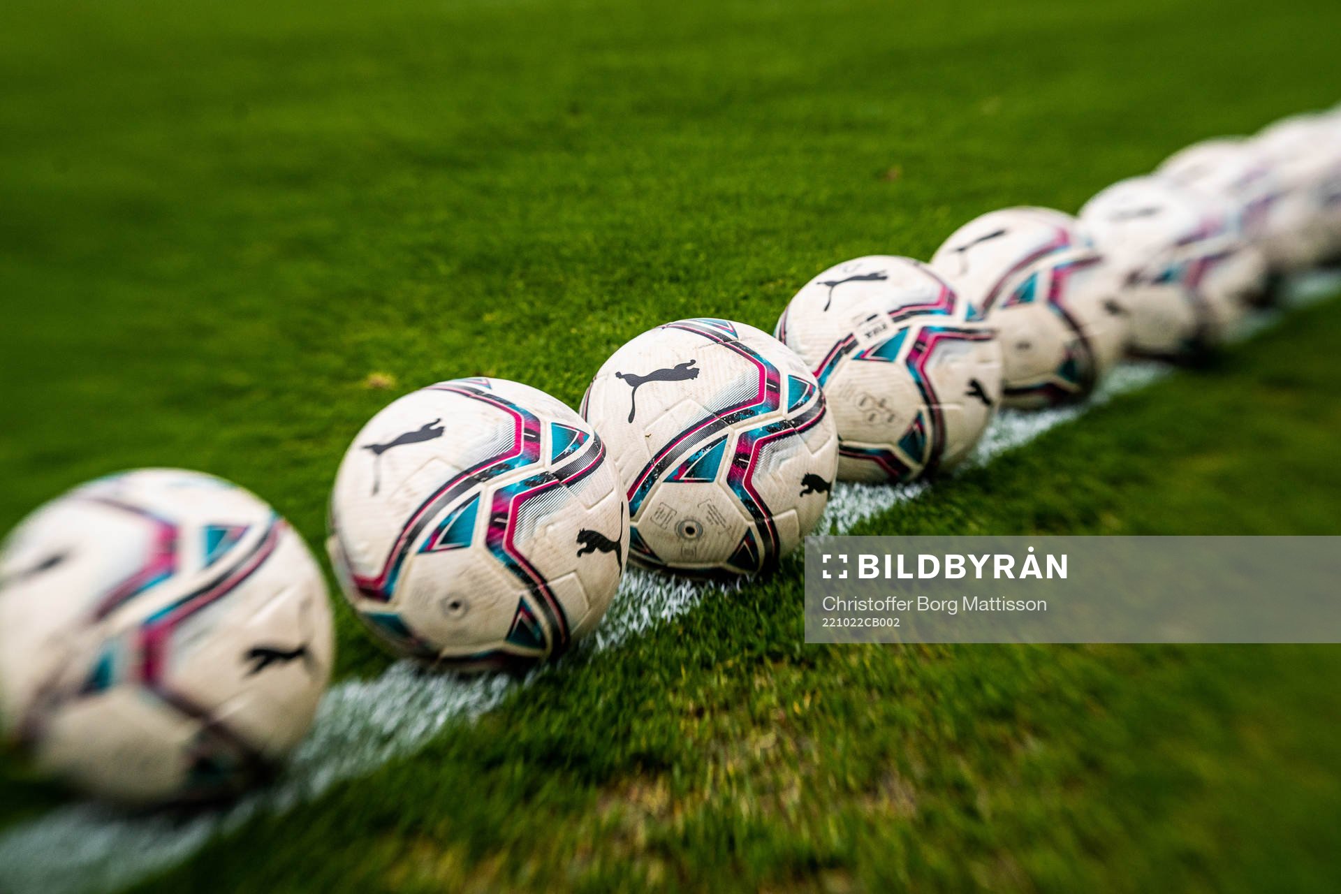Fotbollar ligger på gräsmattan inför fotbollsmatchen i kvalet till damernas Division 1 mellan Malmö FF och Åhus den 22 oktober 2022 i Malmö. Editors note: Bilden är tagen med ett Lensbaby-objektiv