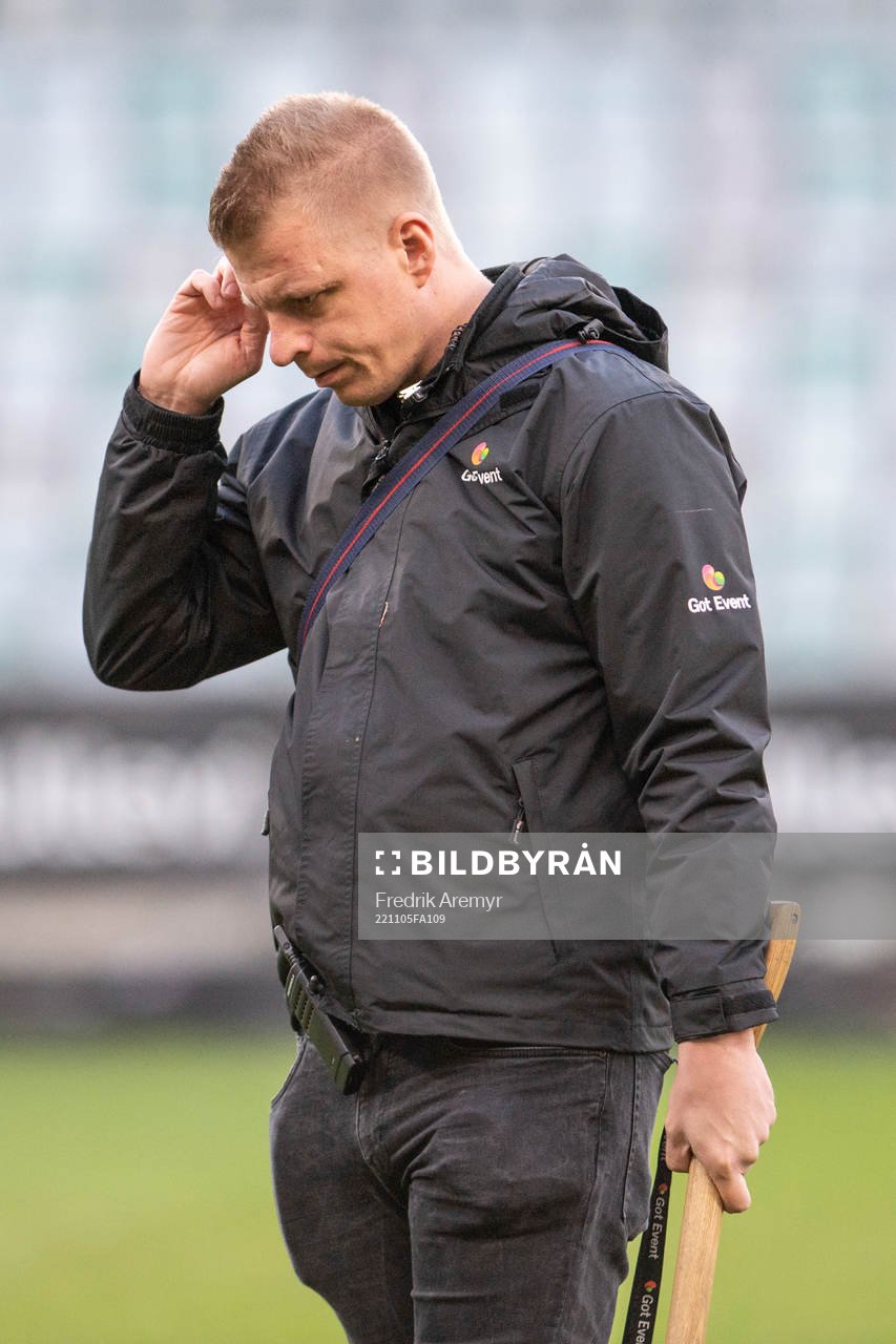 En funktionär inspekterar gräsmattan i halvtidspaus