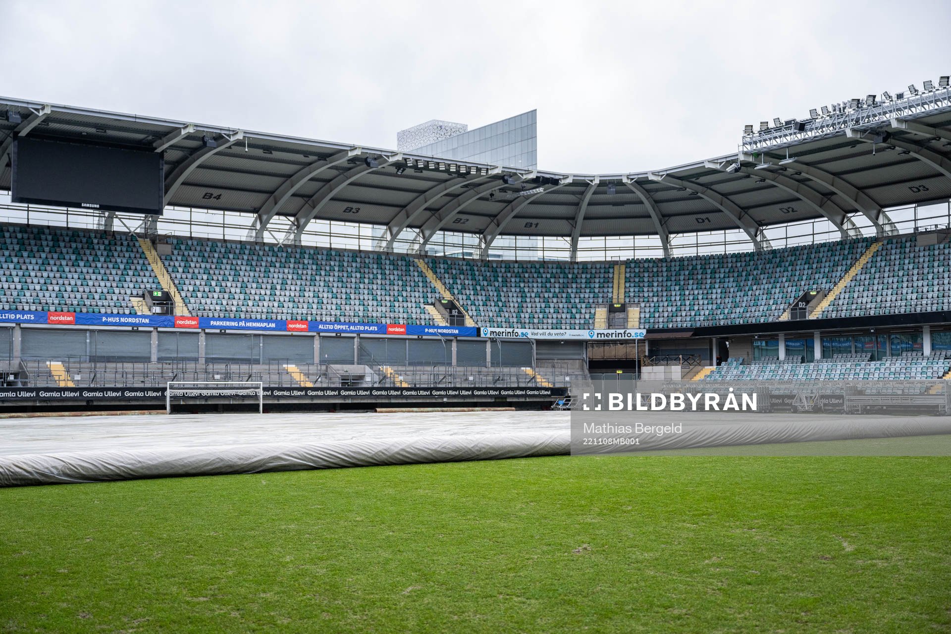 Ett skydd rullas ut över gräset på fotbollsplanen på