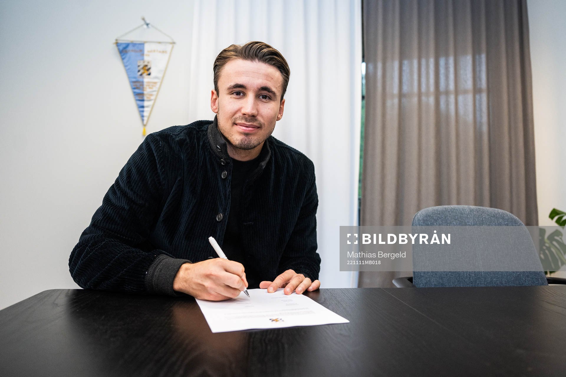 Anders Trondsen signerar kontraktet i samband med att han