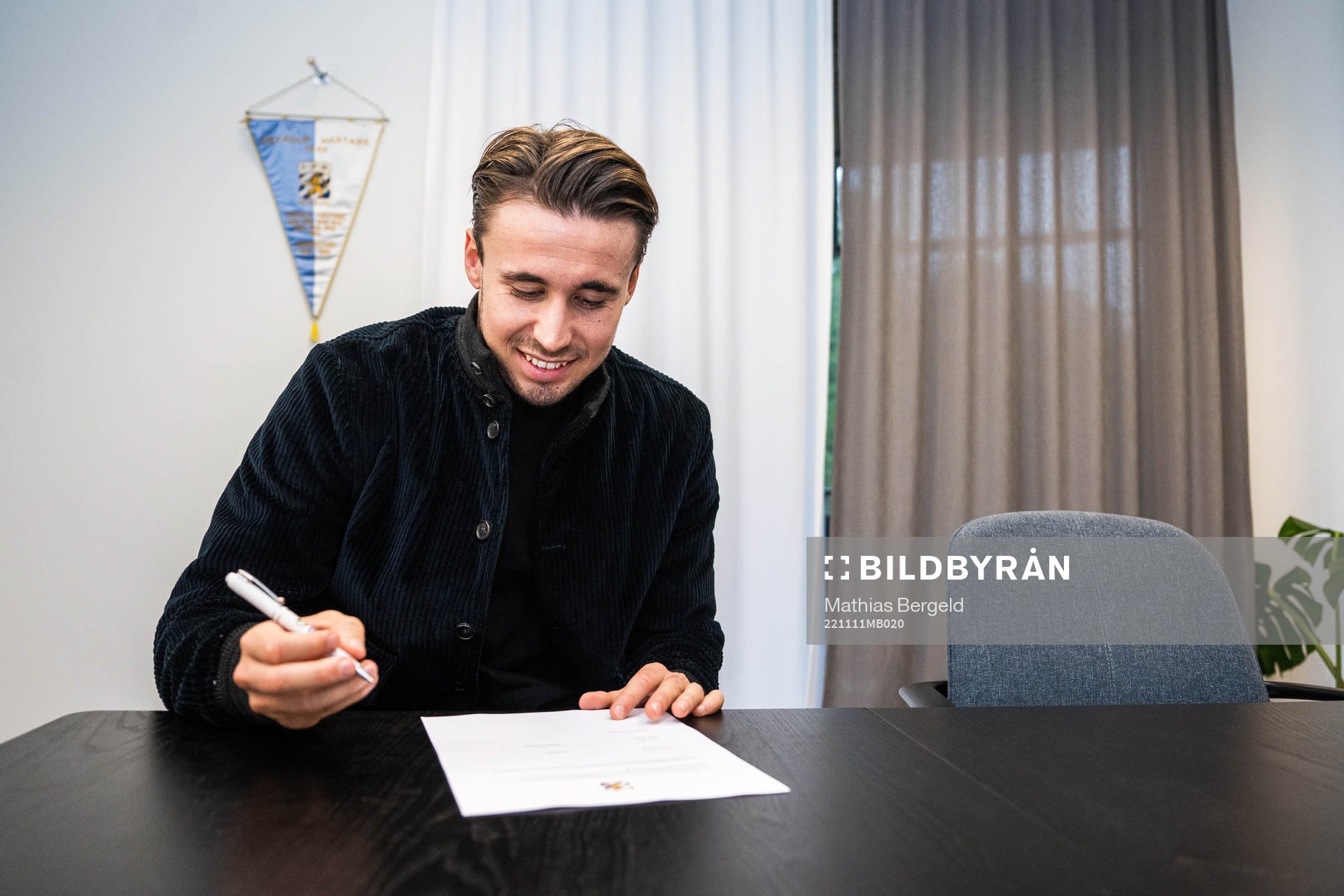 Anders Trondsen signerar kontraktet i samband med att han