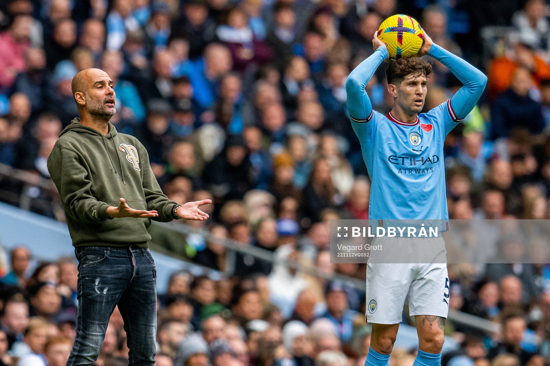 Pep Guardiola, manager of Manchester City, and John Stones