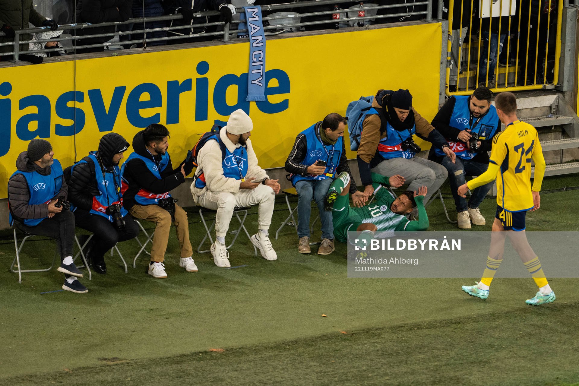 Youcef Belaili of Algeria collides with photographers