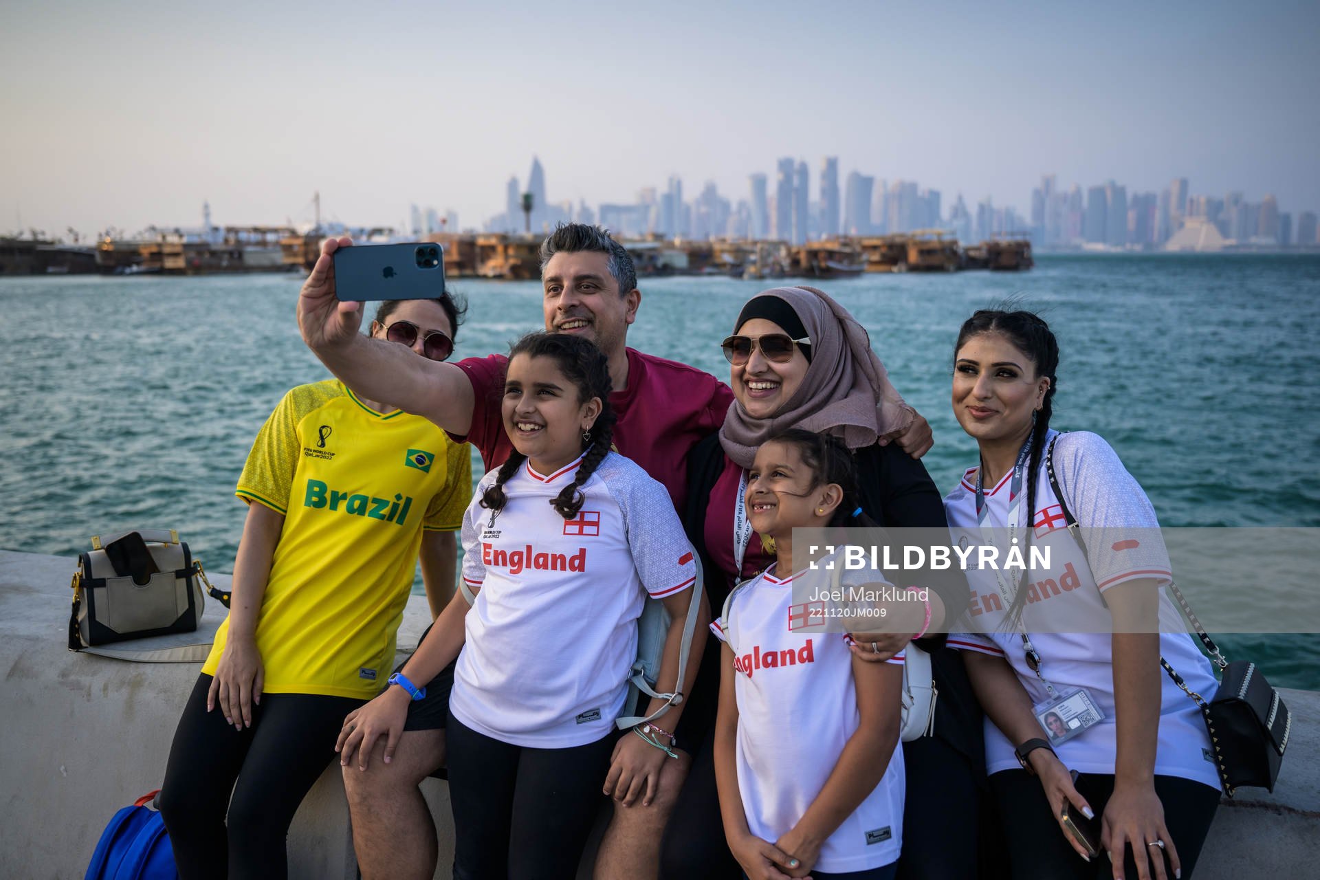 A man takes a selfie with family members at the Corniche