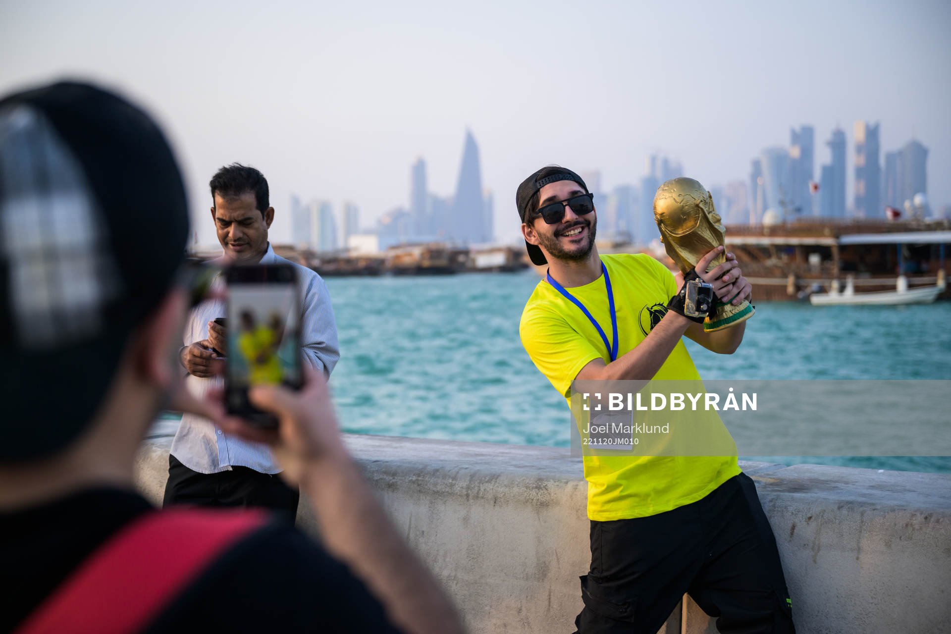 A man poses with a trophy replica at the Corniche Promenade