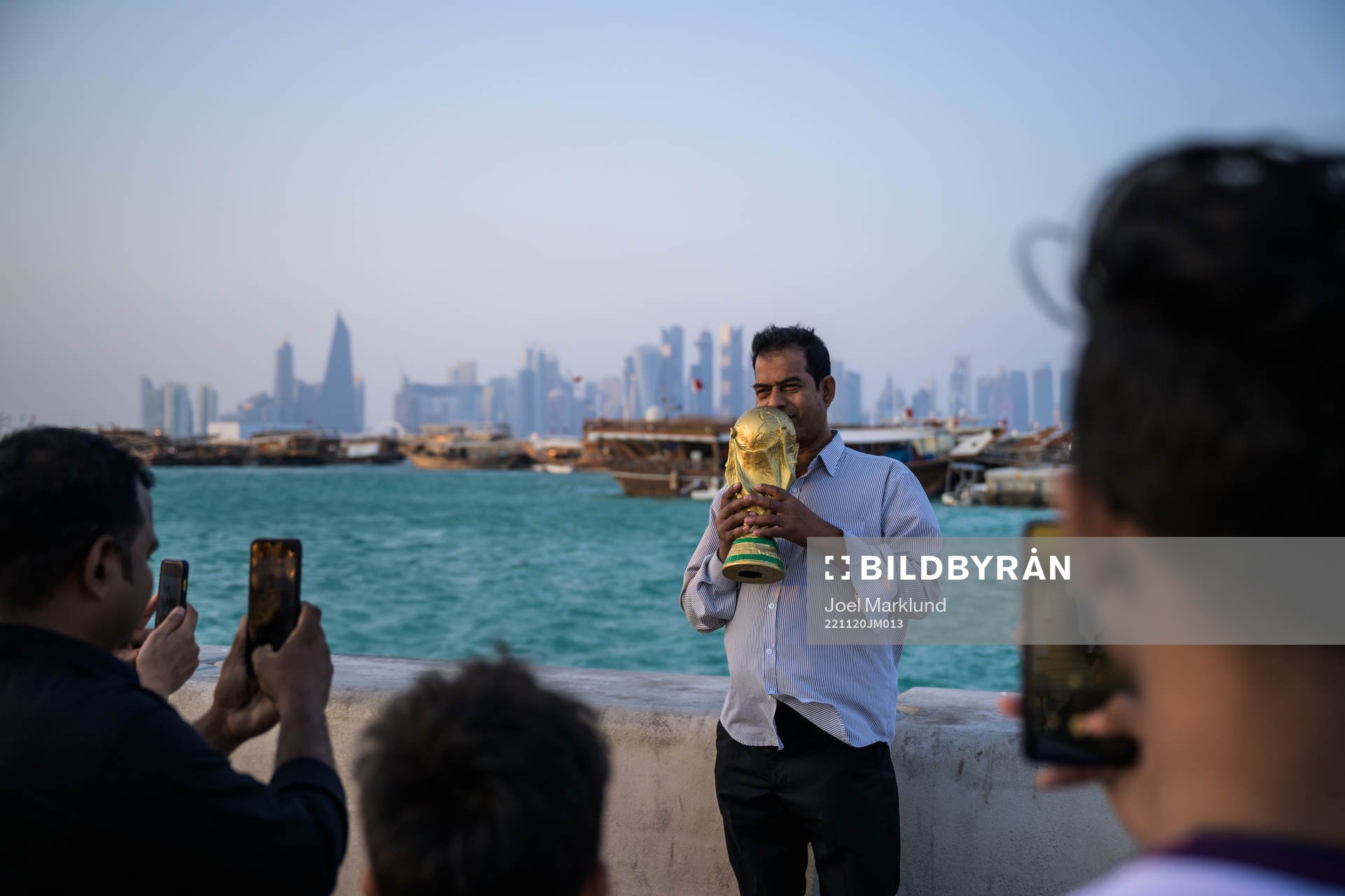 A man poses with a trophy replica at the Corniche Promenade