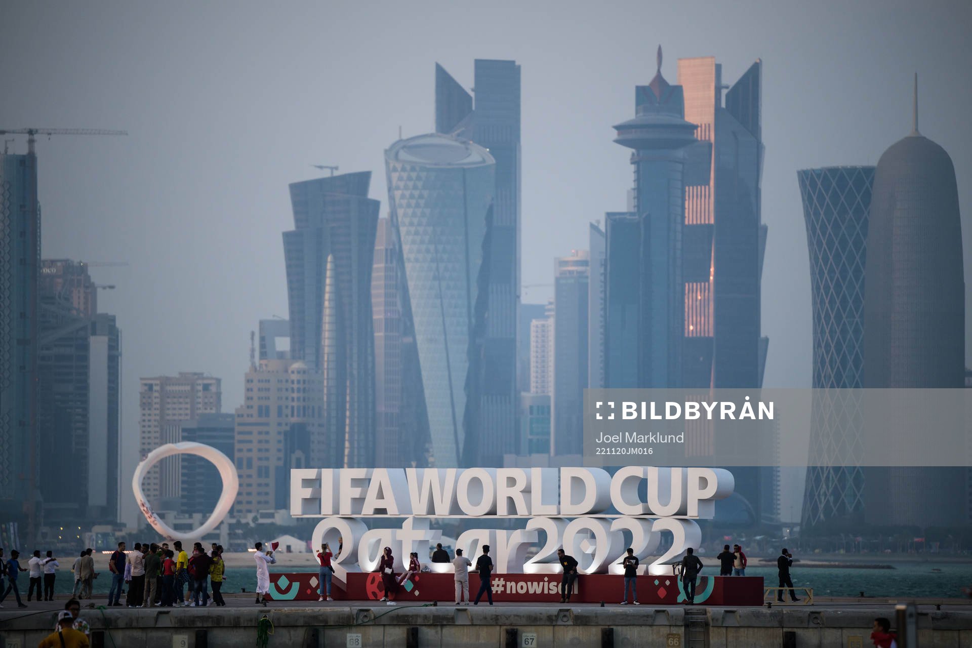 People pose in front of a World Cup logo at Corniche