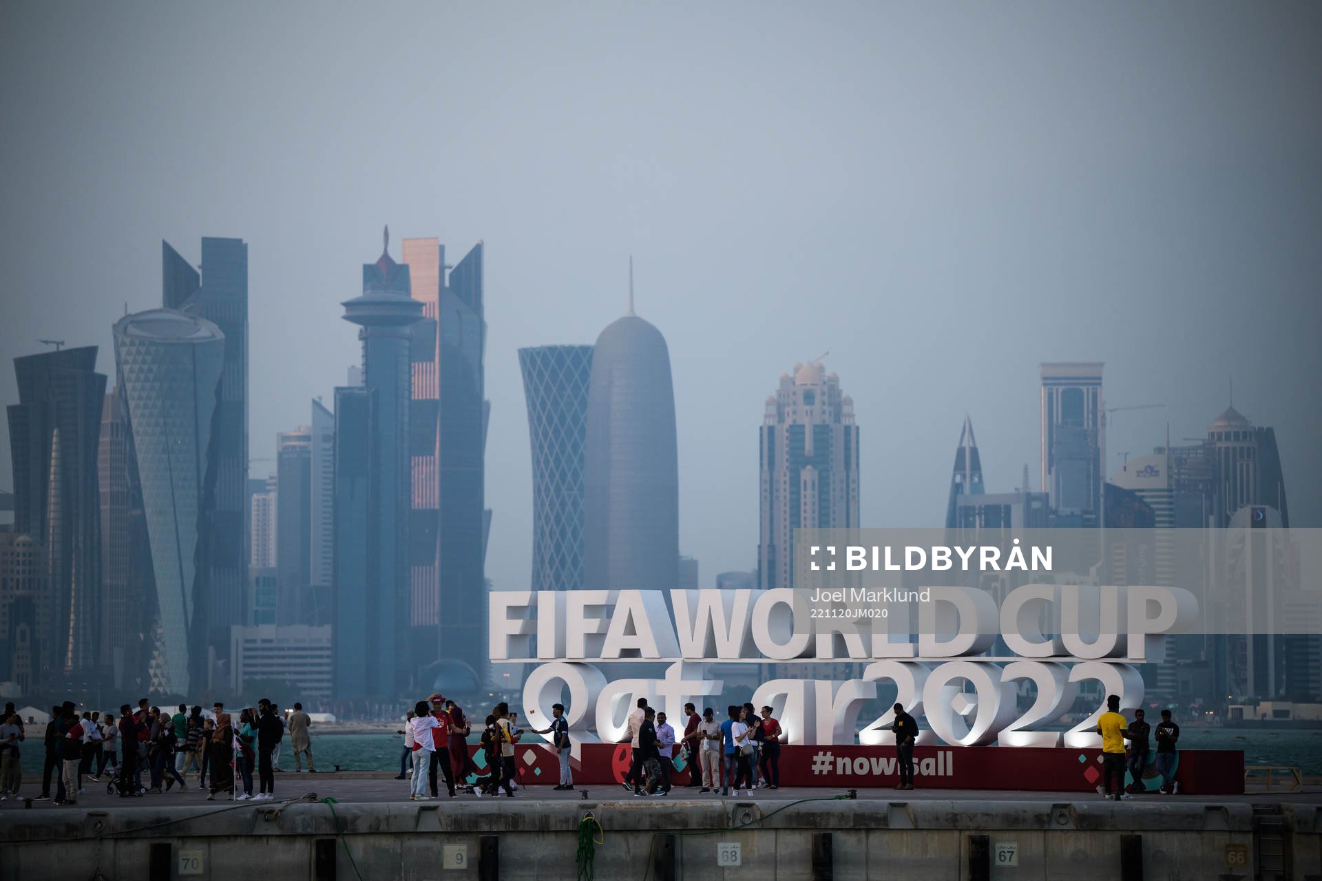 People pose in front of a World Cup logo at Corniche