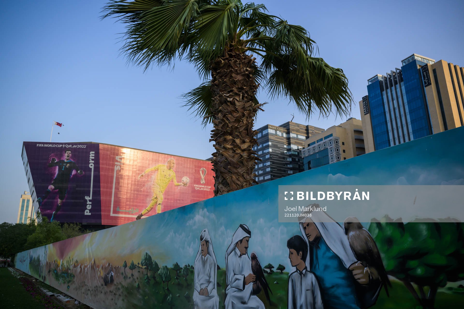 A traditional mural in front of advertising