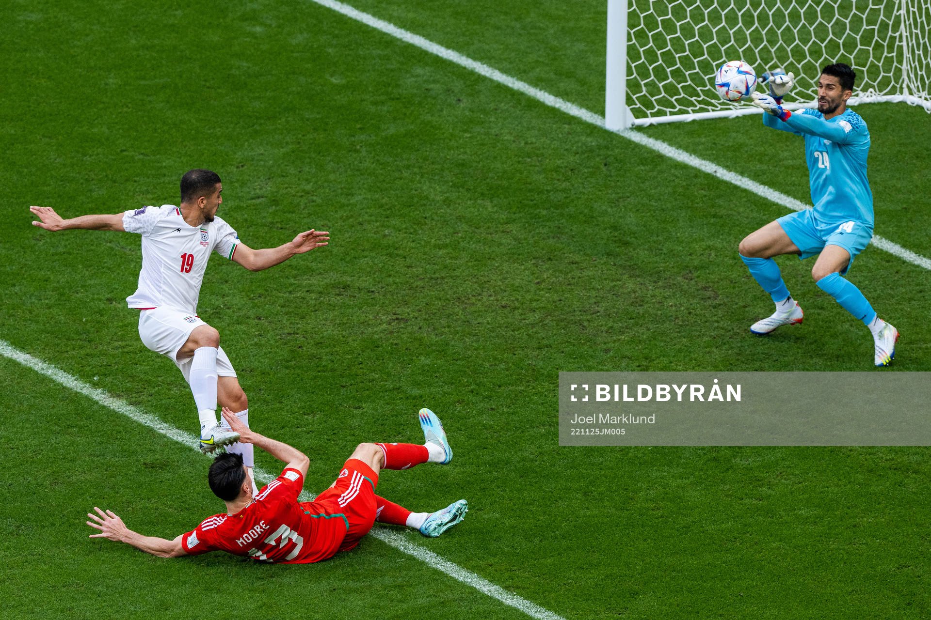 Majid Hosseini and goalkeeper Hossein Hosseini of Iran defend against Kieffer Moore of Wales during the FIFA World Cup 2022 football match between Wales and Iran on November 25, 2022 in Doha.