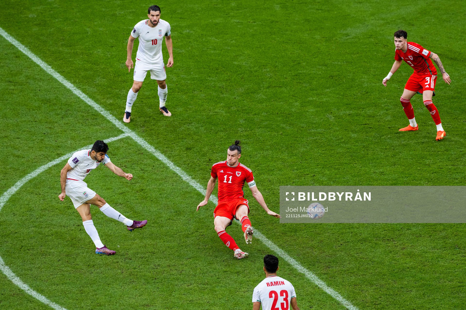 Mehdi Torabi of Iran shoots past Gareth Bale< of Wales