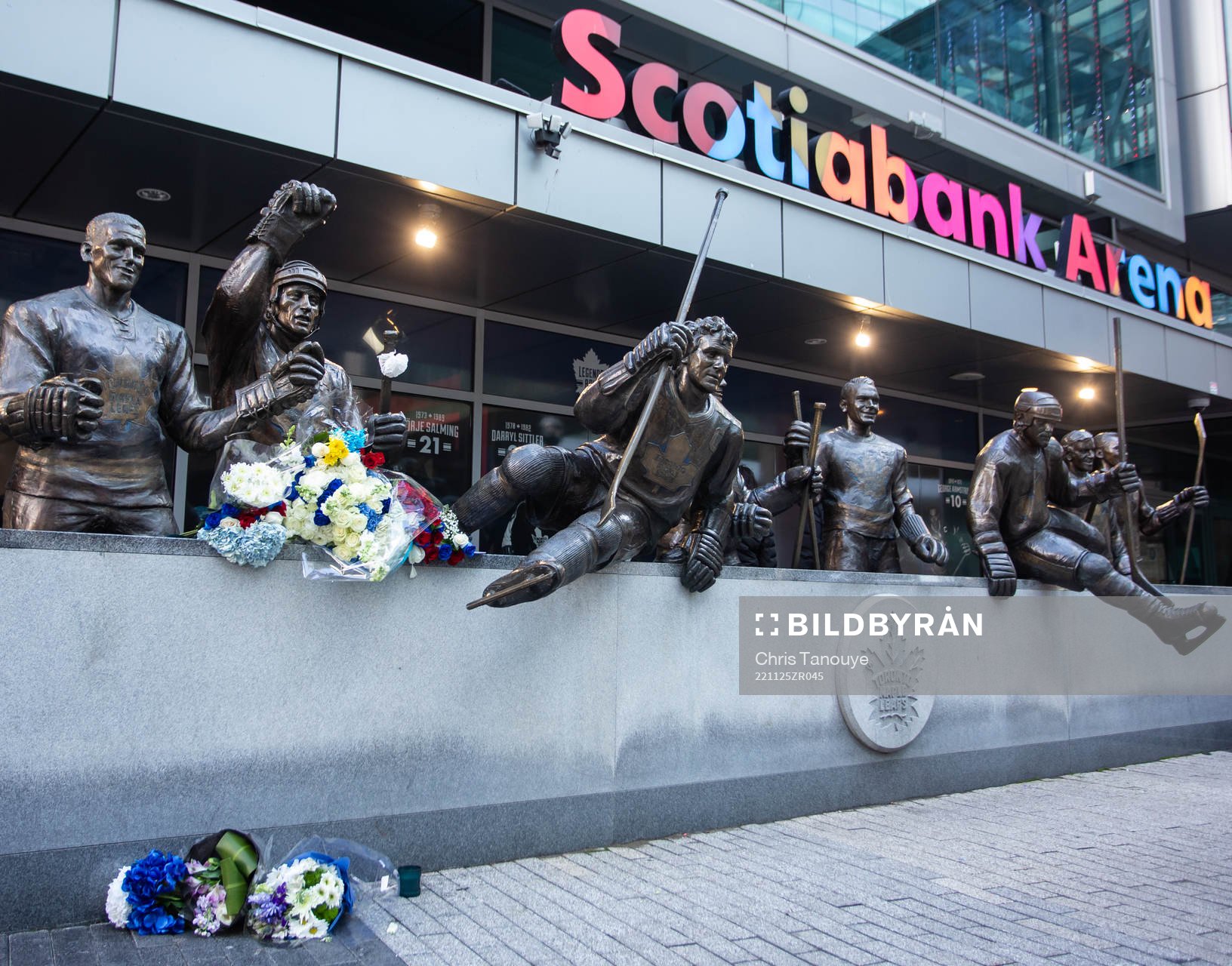 Flowers are shown in memorial at a statue of the late