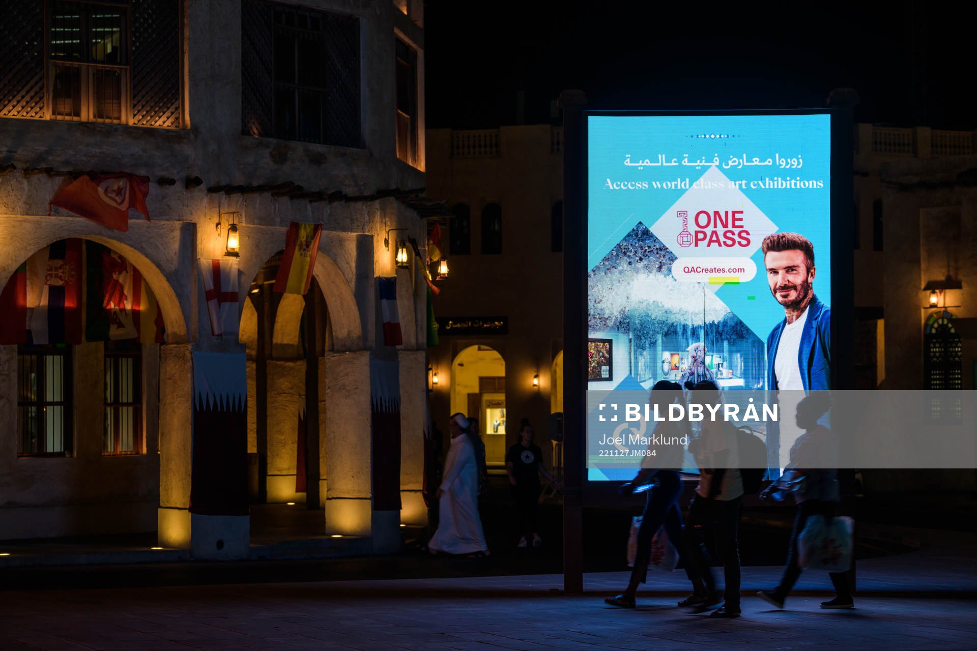 People walk past an ad with David Beckham